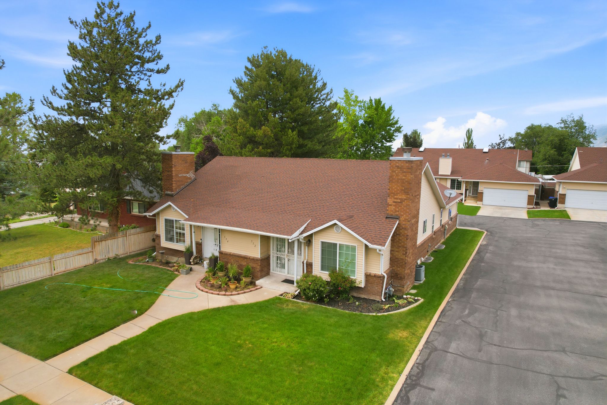 Single-story residence featuring a classic brown shingle roof, light-colored siding, and brick accents