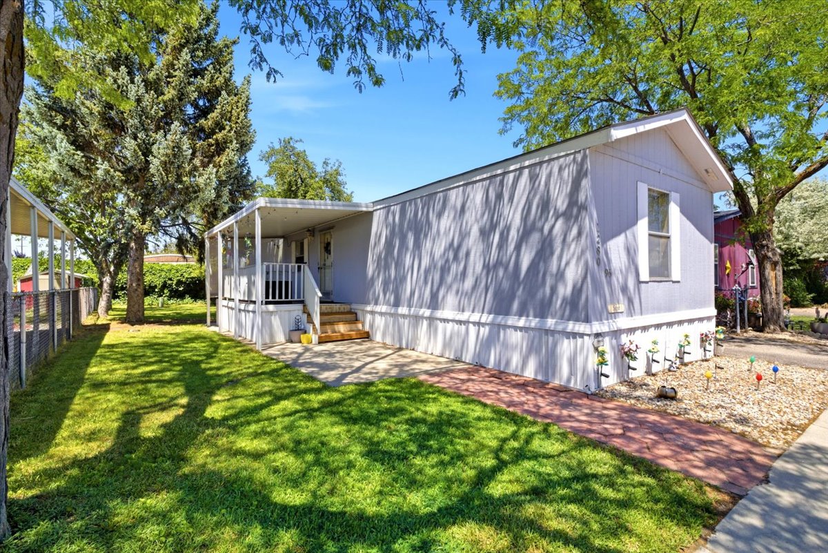 Light-colored exterior with a covered porch and wood steps