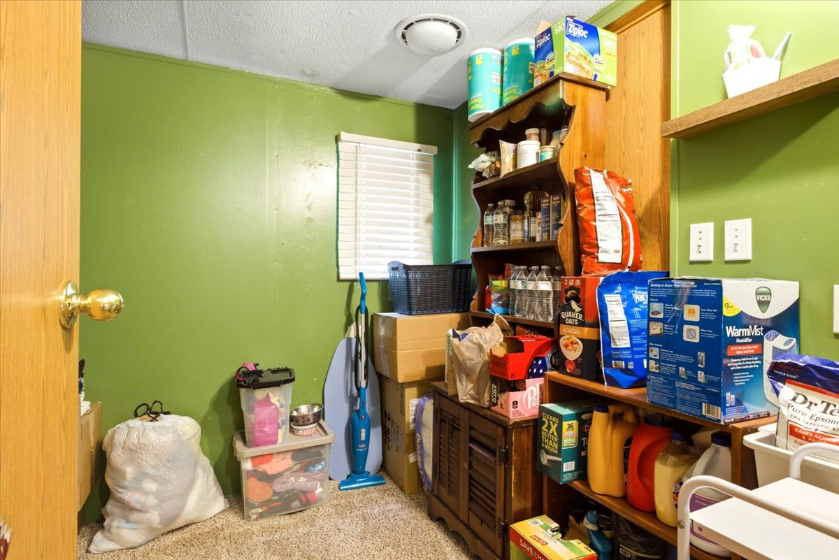 Dedicated room featuring wall-mounted shelving and additional storage cabinetry