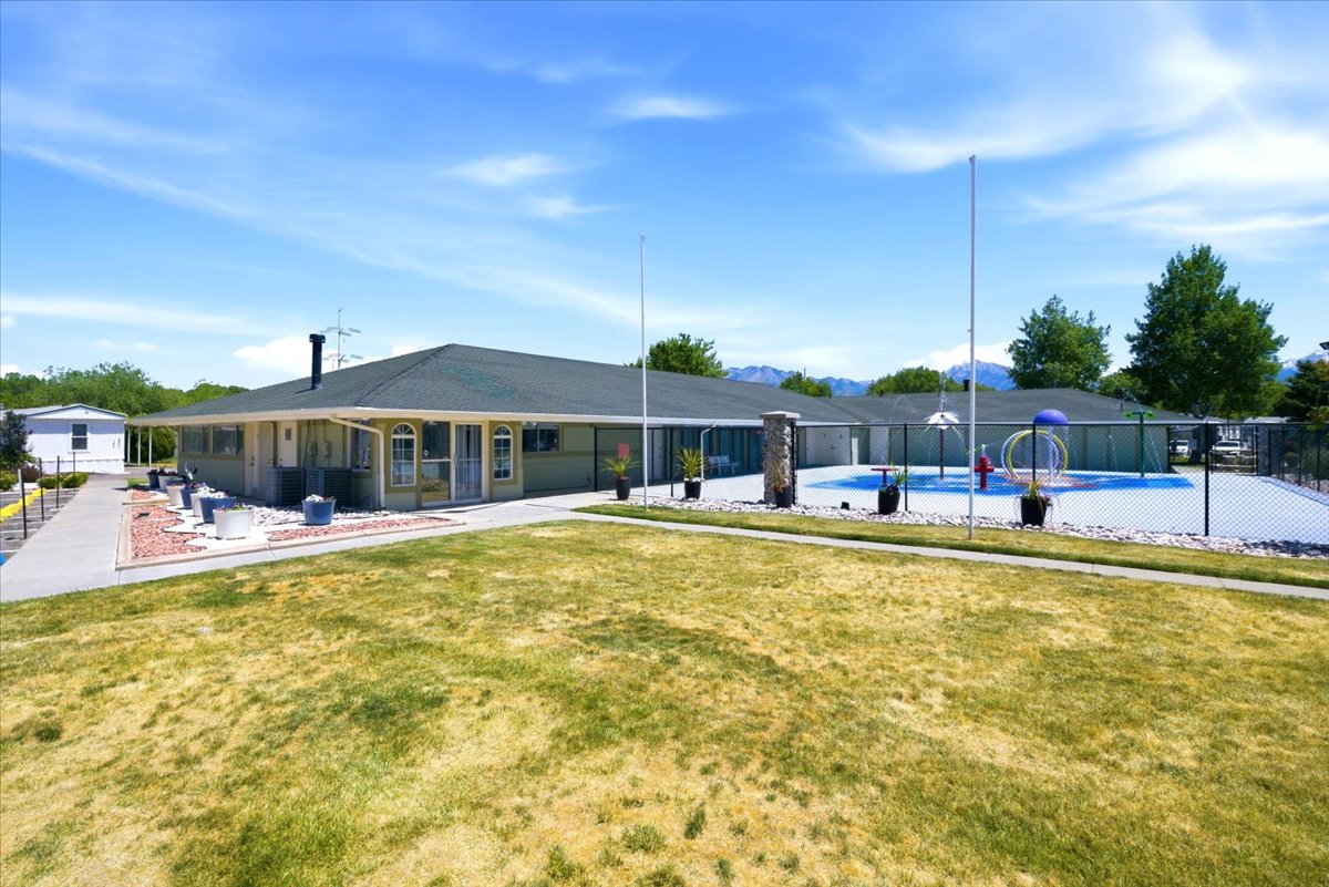 Single-story building with a dark green roof and light green siding