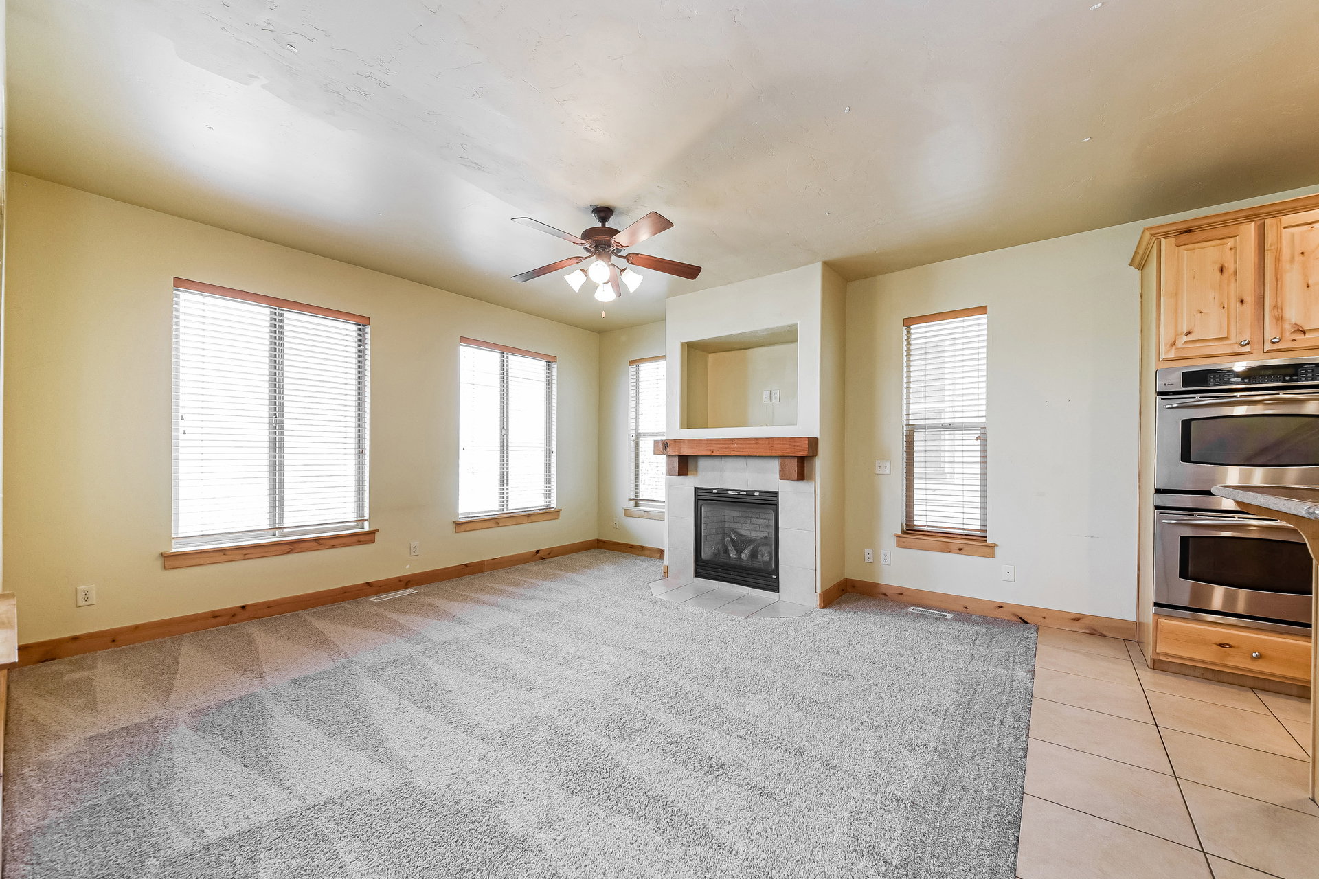 Living area featuring a gas fireplace with a wooden mantel and tile surround
