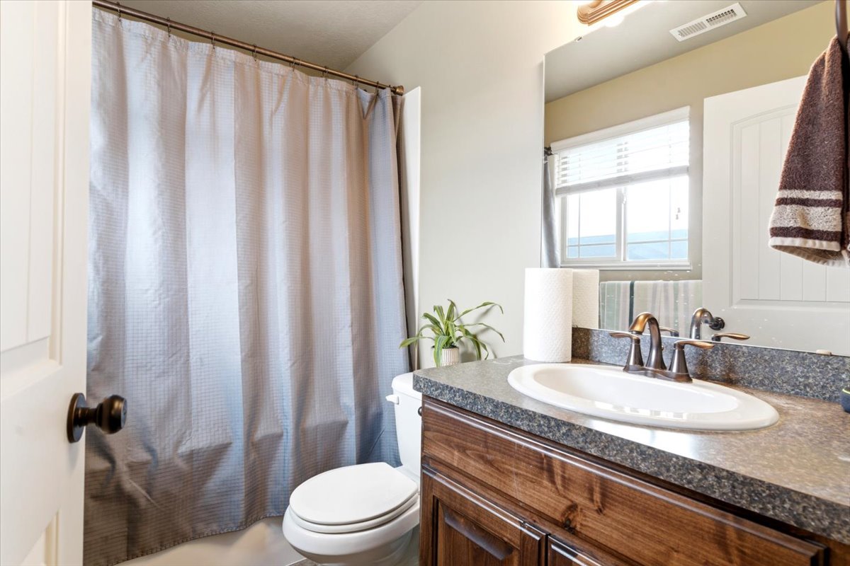 Bathroom vanity with a dark wood-finish cabinet and a speckled countertop
