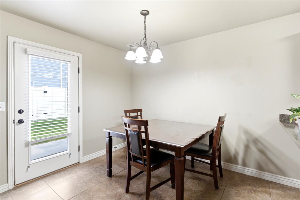 Tile flooring extending throughout the space with a full-view exterior door featuring integrated blinds