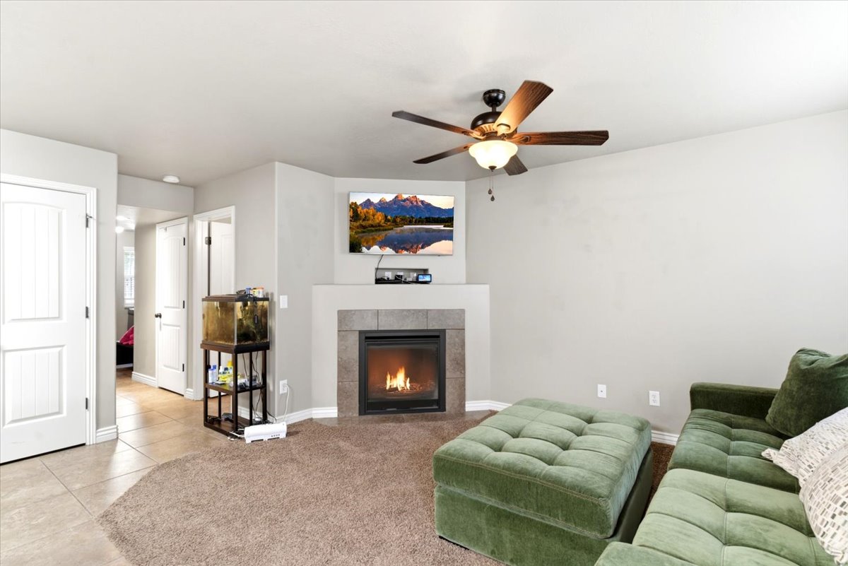 Living area featuring a corner fireplace with a dark tile surround and a stone mantel
