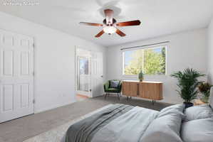 Carpeted bedroom featuring a ceiling fan, two paneled doors, and a window with horizontal blinds
