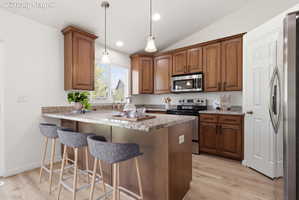 Kitchen featuring an island with a breakfast bar, wood-finish flooring, granite countertops, wood cabinetry, and stainless steel appliances