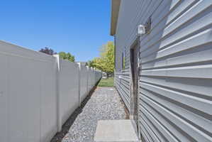 Exterior siding in a light gray finish with a contrasting white vinyl fence
