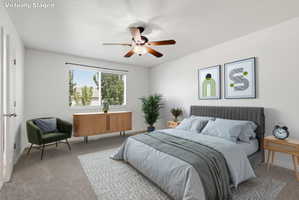 Carpeted bedroom with a ceiling fan light fixture and dual windows featuring blinds