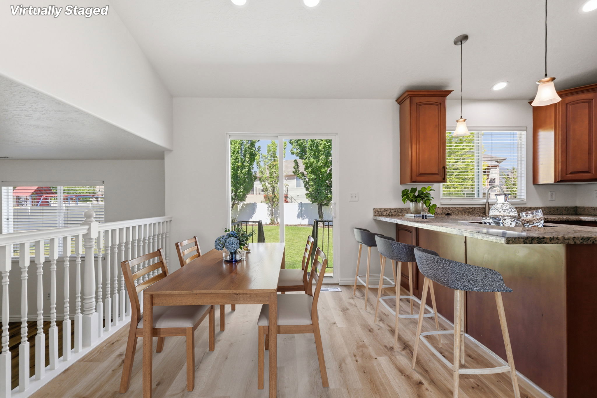 Open-concept living space featuring wood-finish flooring and a white spindle railing