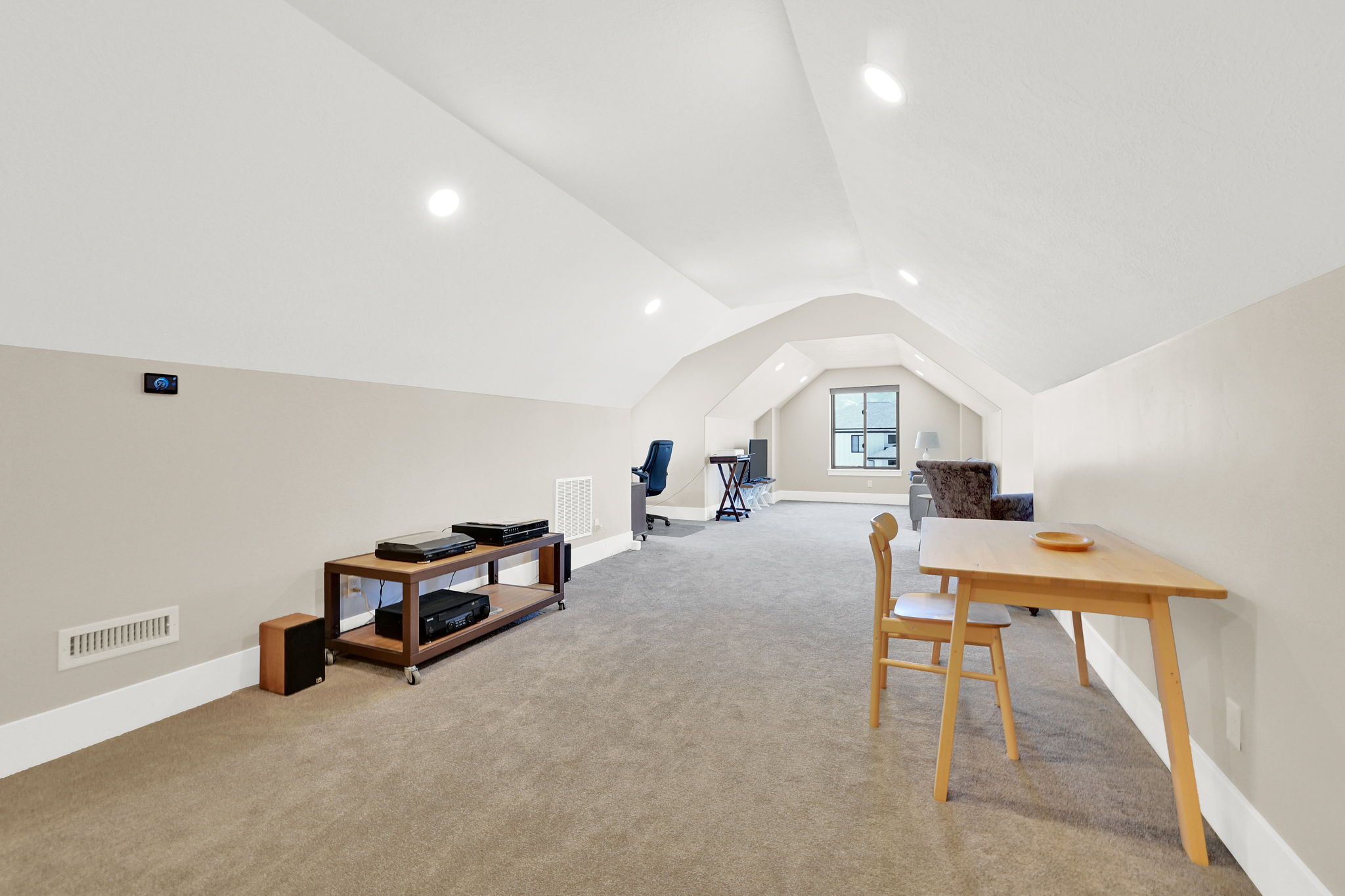 Expansive carpeted bonus room featuring recessed lighting, a vaulted ceiling, and a prominent window providing natural light