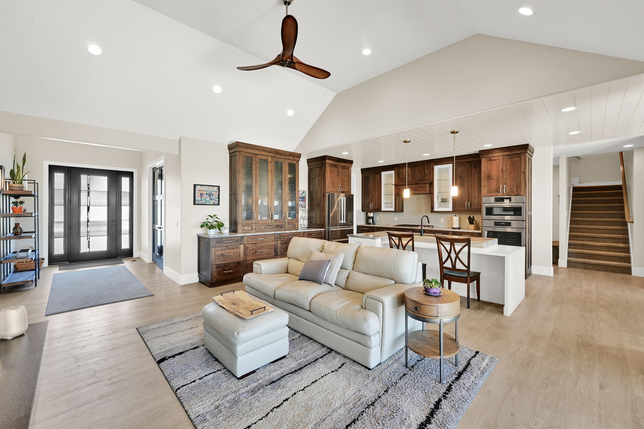 Vaulted ceiling with a wood-finish ceiling fan and recessed lighting