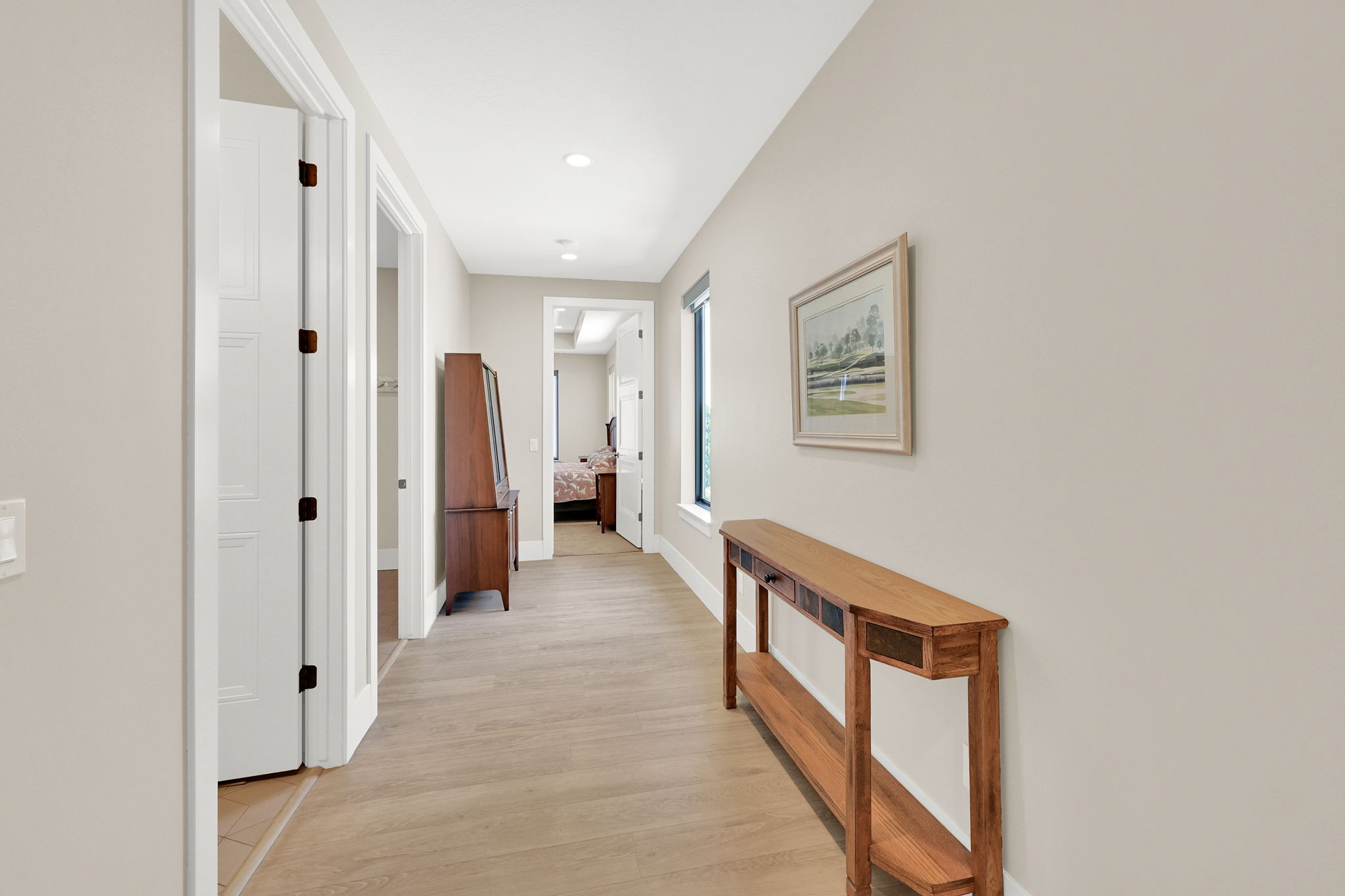 Interior hallway featuring light wood-finish flooring and neutral wall tones