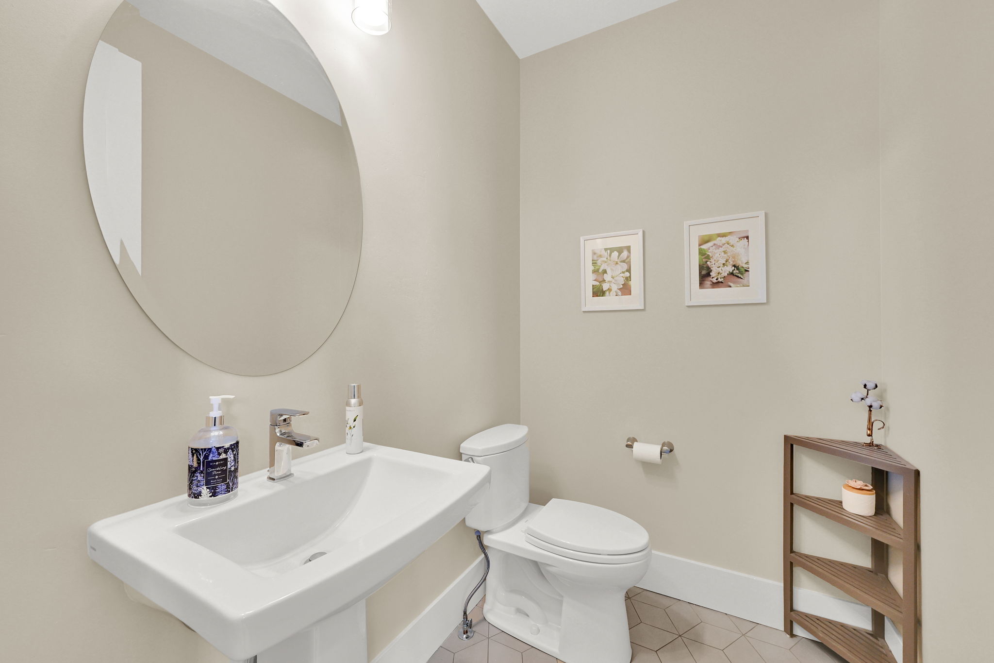 Powder room featuring a pedestal sink with a chrome faucet, oval mirror, and a modern toilet