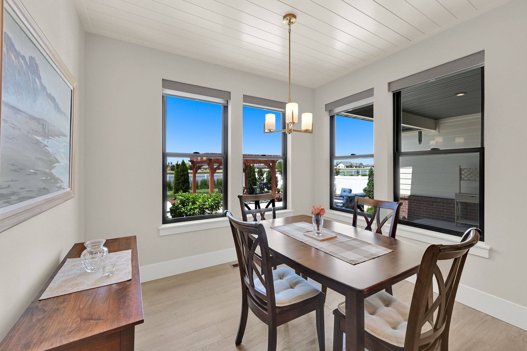 Dining area featuring light wood-finish flooring, white shiplap ceiling, and a multi-light chandelier