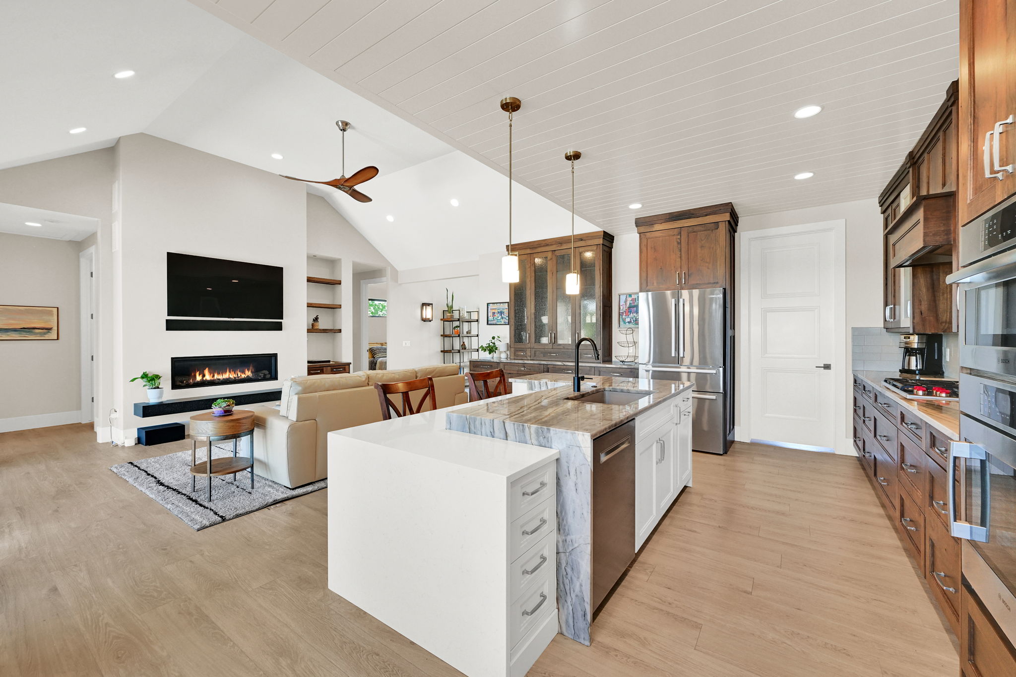 Open-concept living space featuring vaulted ceilings with wood-finish flooring
