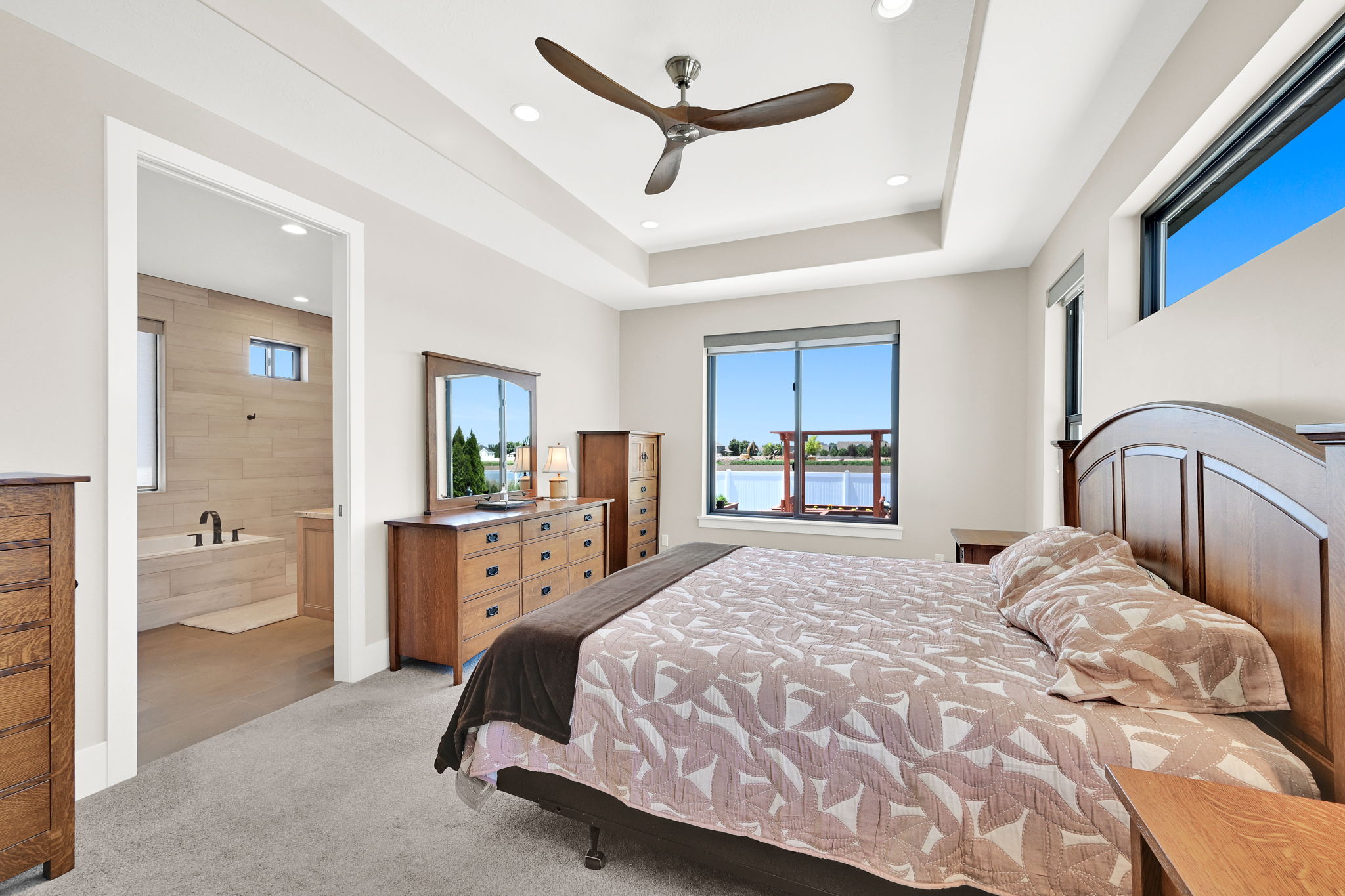 Carpeted room featuring a tray ceiling with recessed lighting and a ceiling fan