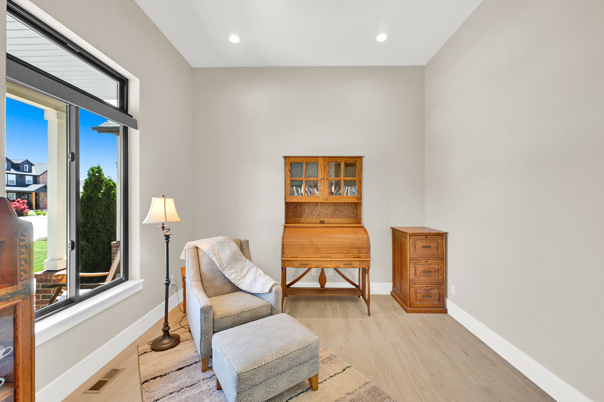 Bright interior space featuring light-toned walls, wood-finish flooring, and recessed ceiling lighting