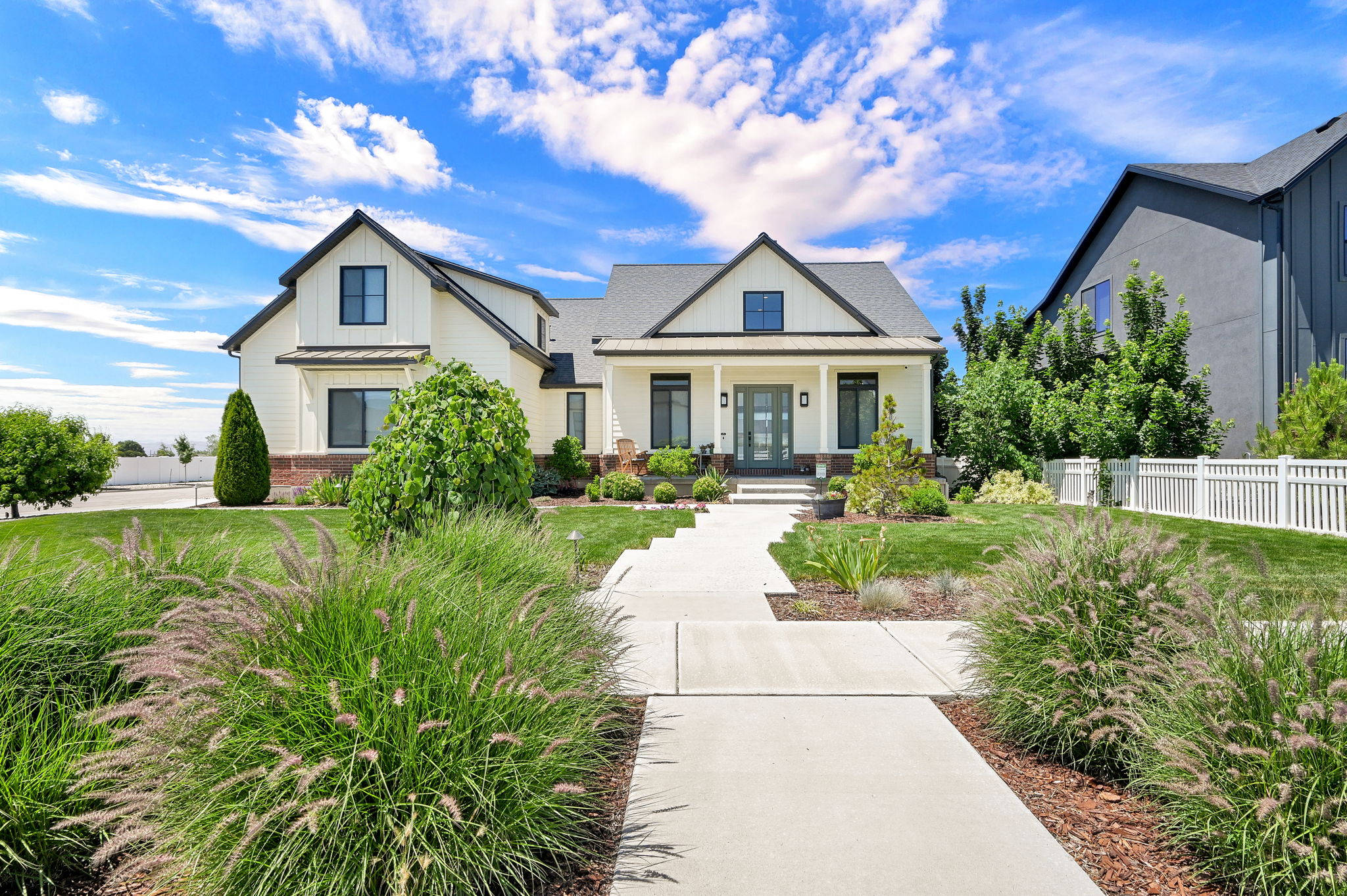 Modern farmhouse exterior featuring light-colored siding with dark trim accents and a contrasting roof