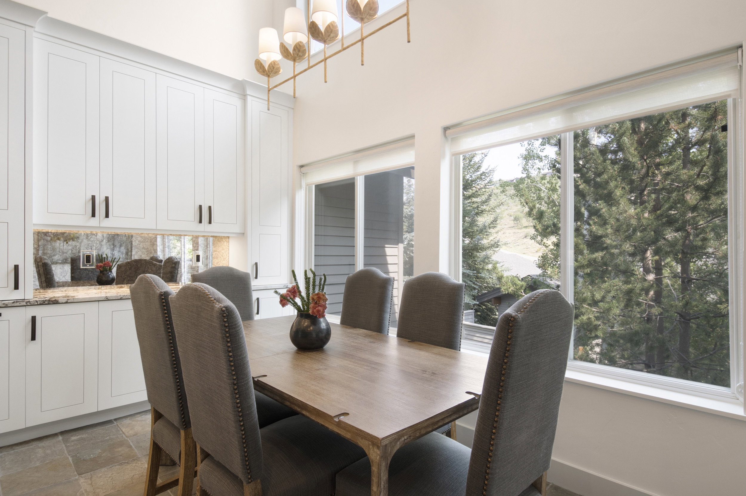 Dining area featuring floor-to-ceiling white cabinetry with dark hardware and under-cabinet lighting