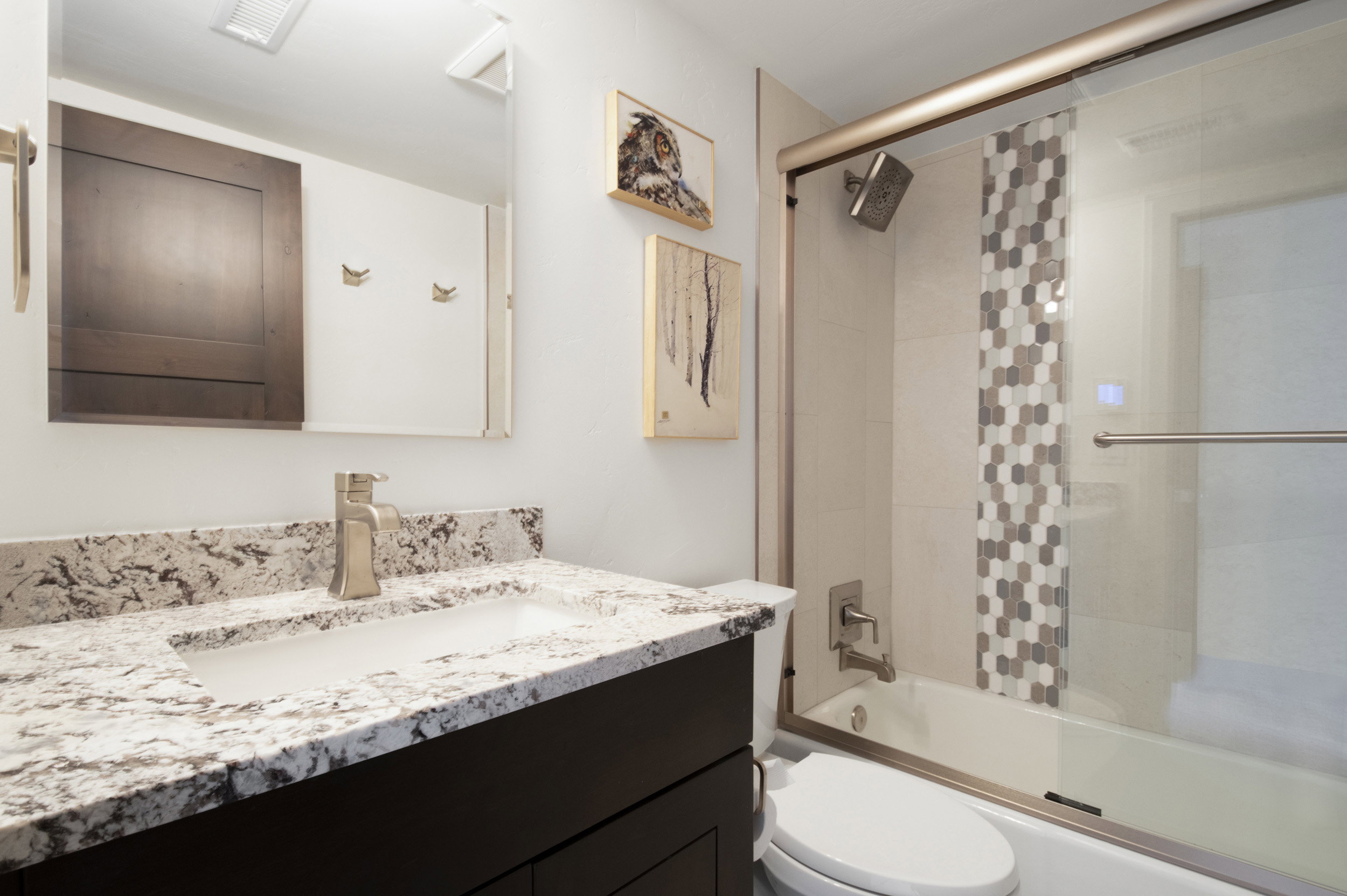 Bathroom featuring a dark wood-finish vanity with an integrated sink and a speckled countertop
