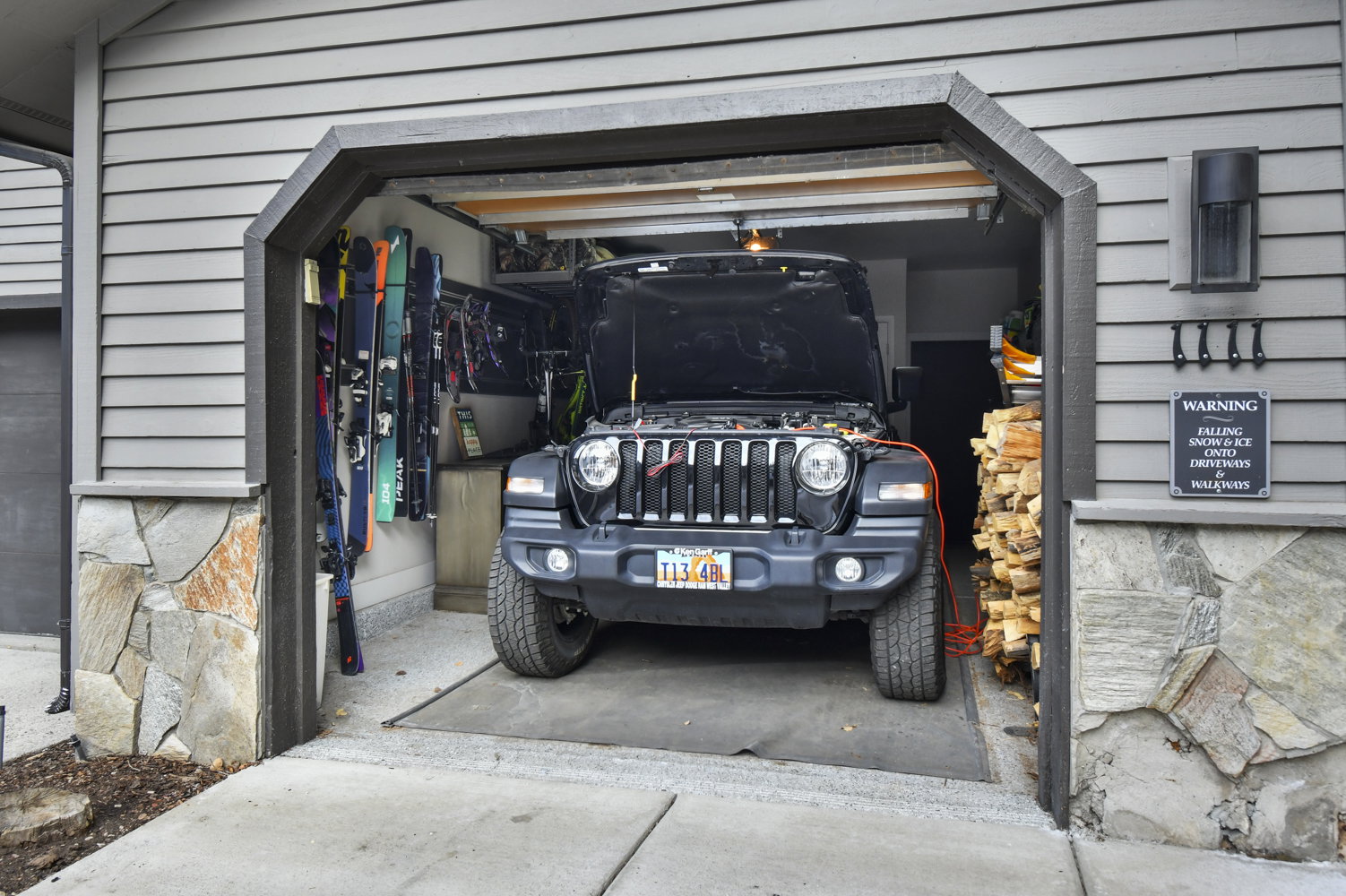 Attached garage with horizontal siding and stone veneer accents