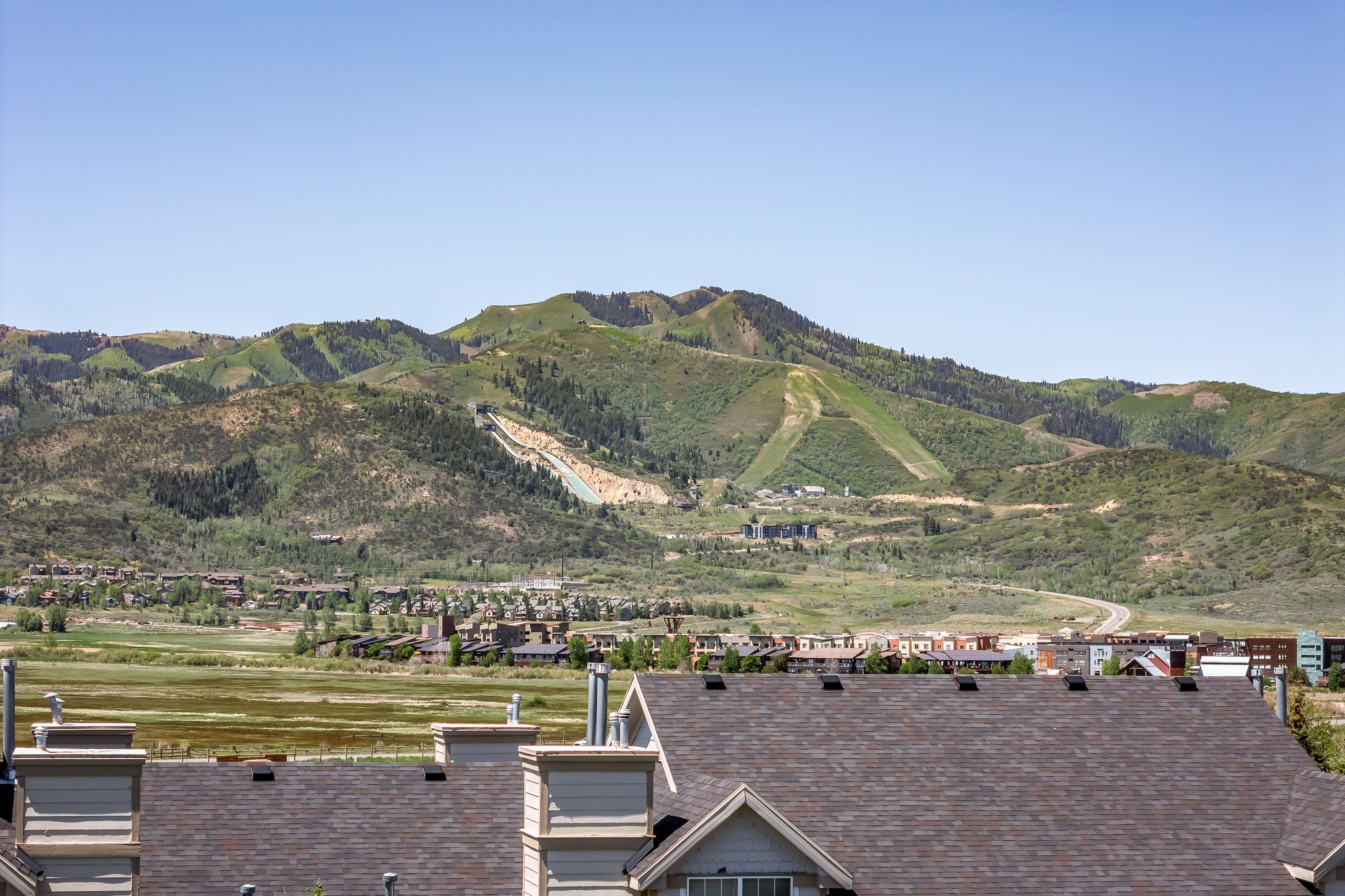 Mountainous terrain featuring ski slopes, forested areas, and a community of residential structures