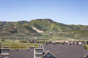 Mountainous terrain featuring ski slopes, forested areas, and a community of residential structures