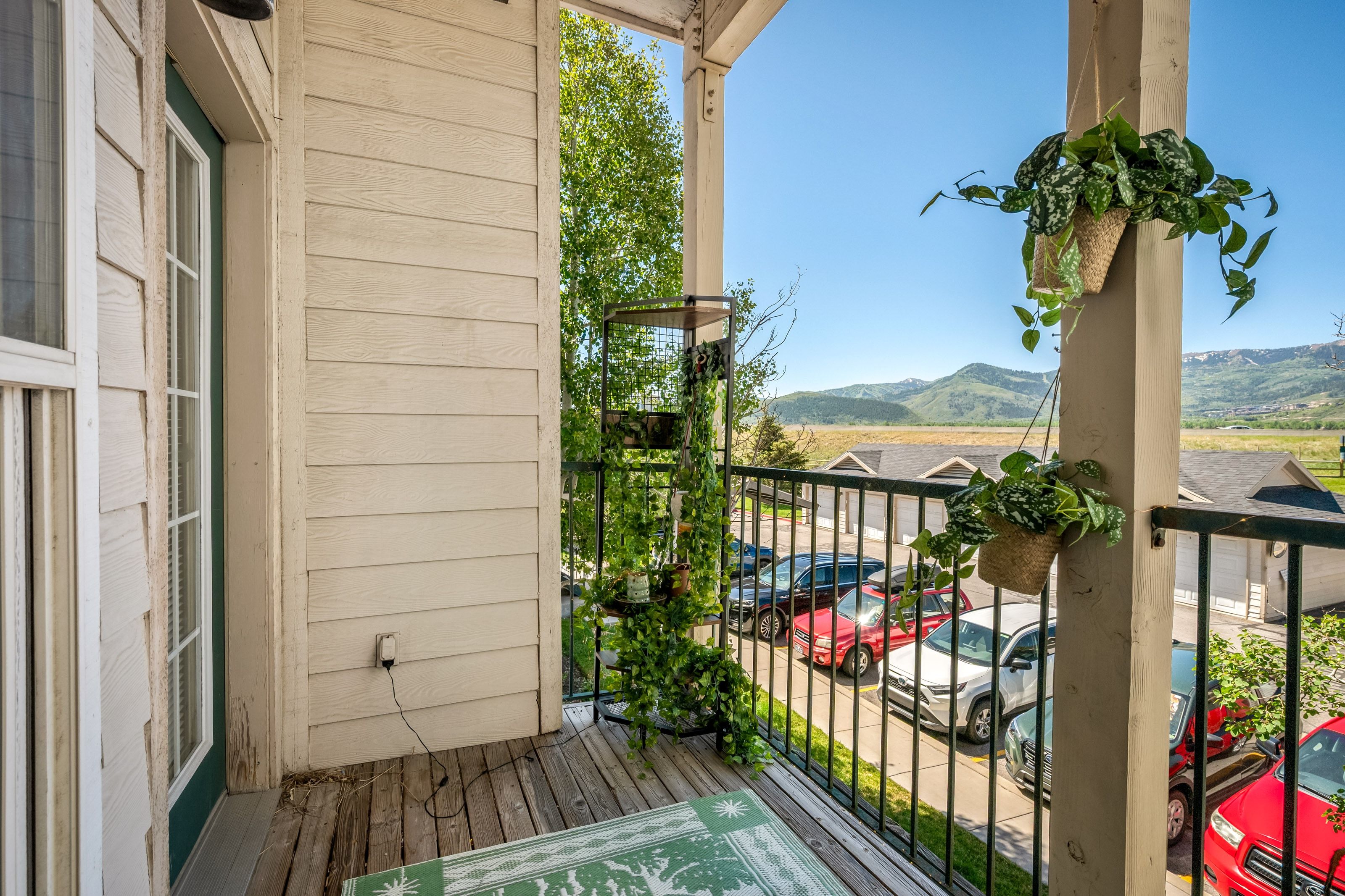 Balcony with wood-finish flooring, white siding, and black metal railings