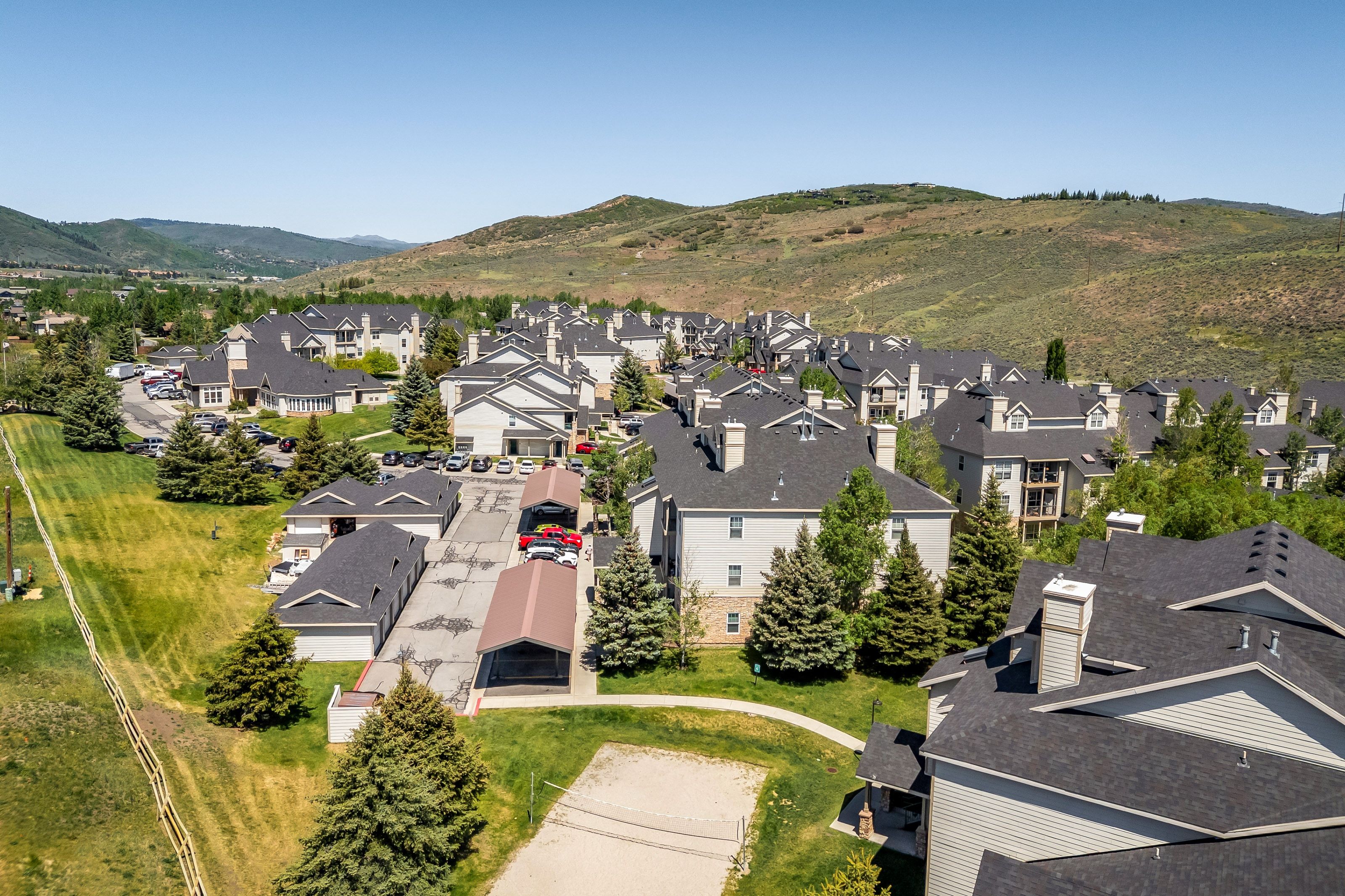 Expansive residential development featuring multiple buildings with dark shingle roofs, dormer windows, and light-colored siding