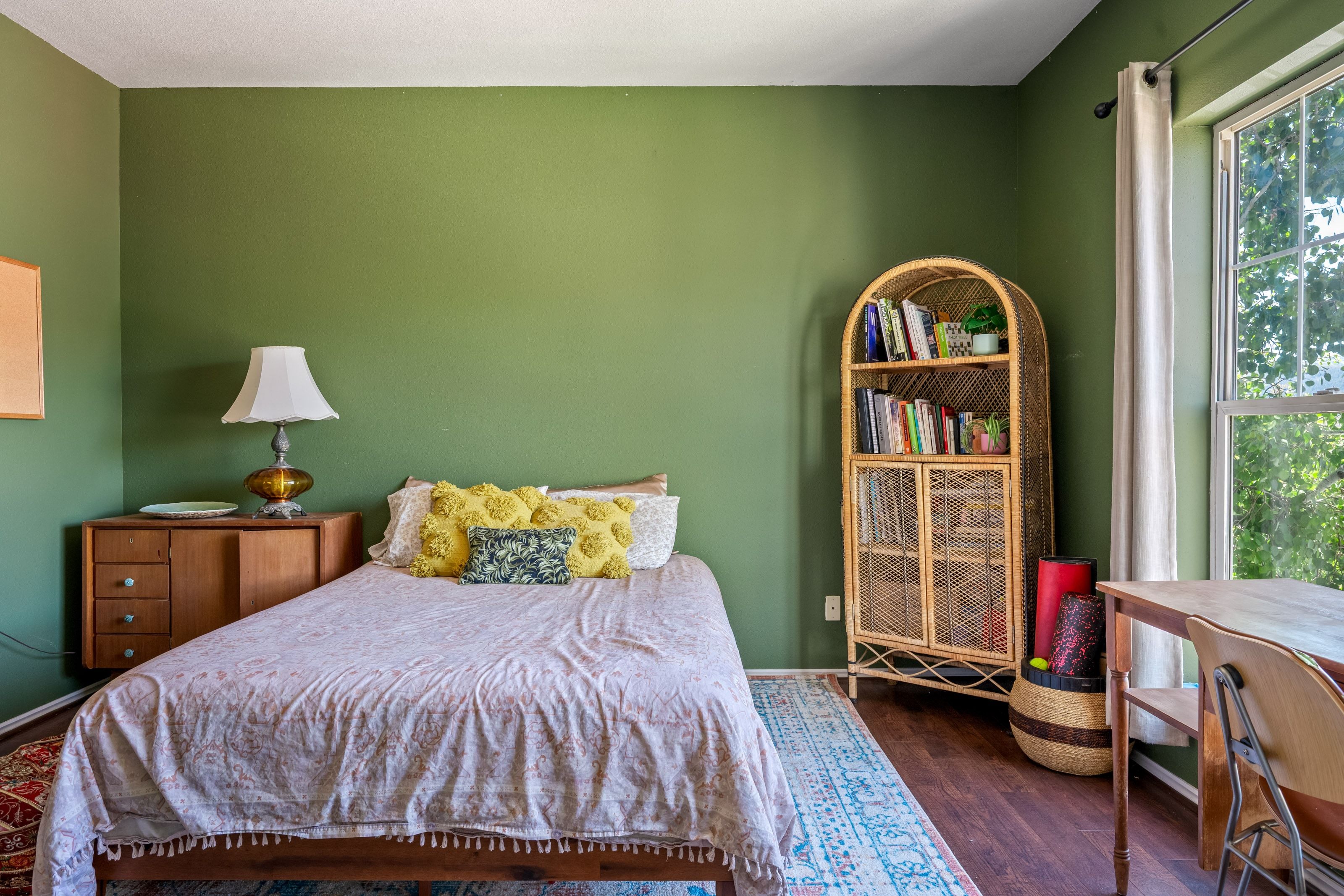 Room featuring rich green walls and wood-finish flooring