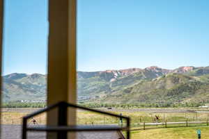 Expansive mountain landscape visible through a large window, featuring distant peaks with varied foliage