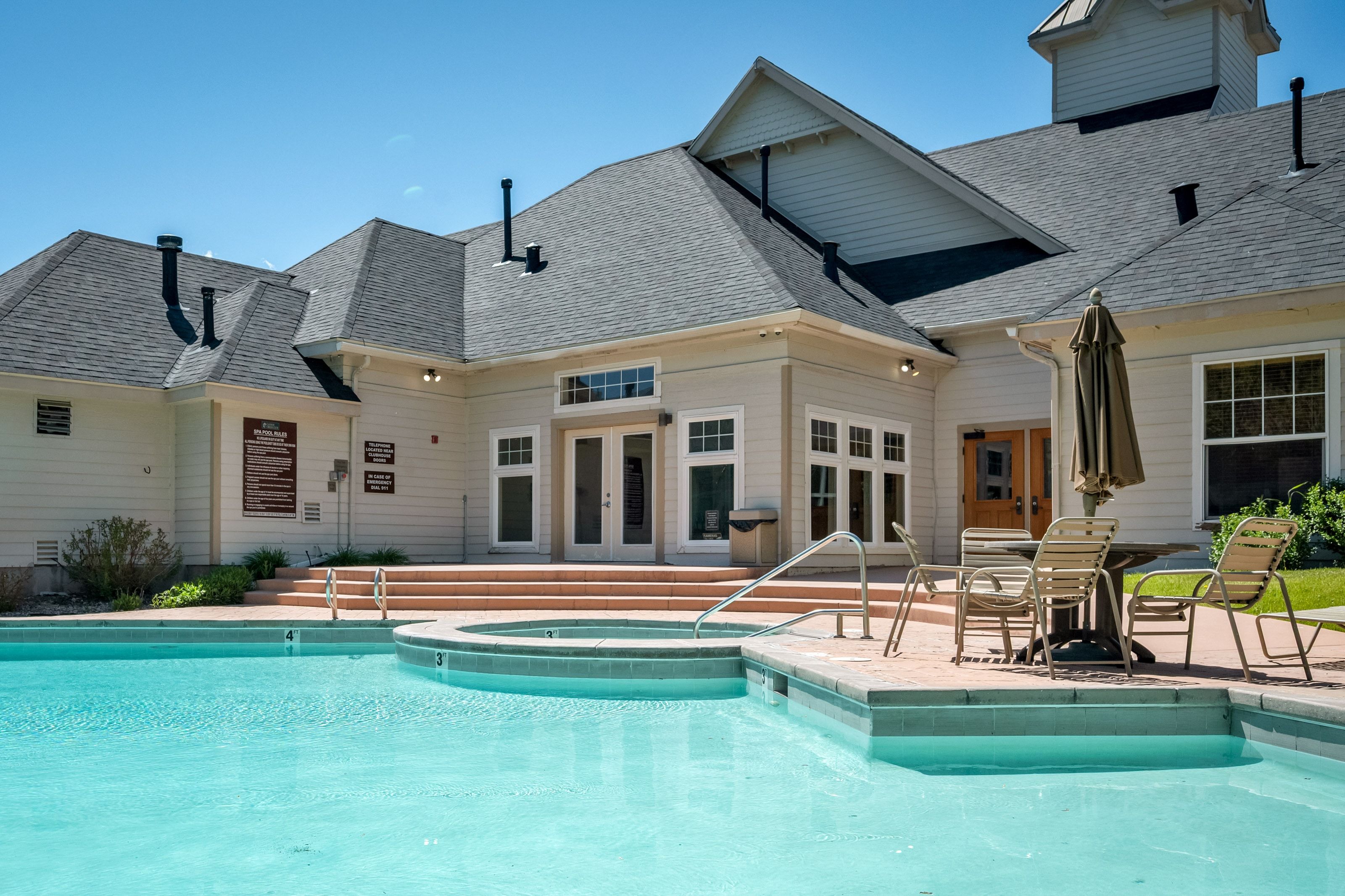 Outdoor swimming pool with integrated spa tub