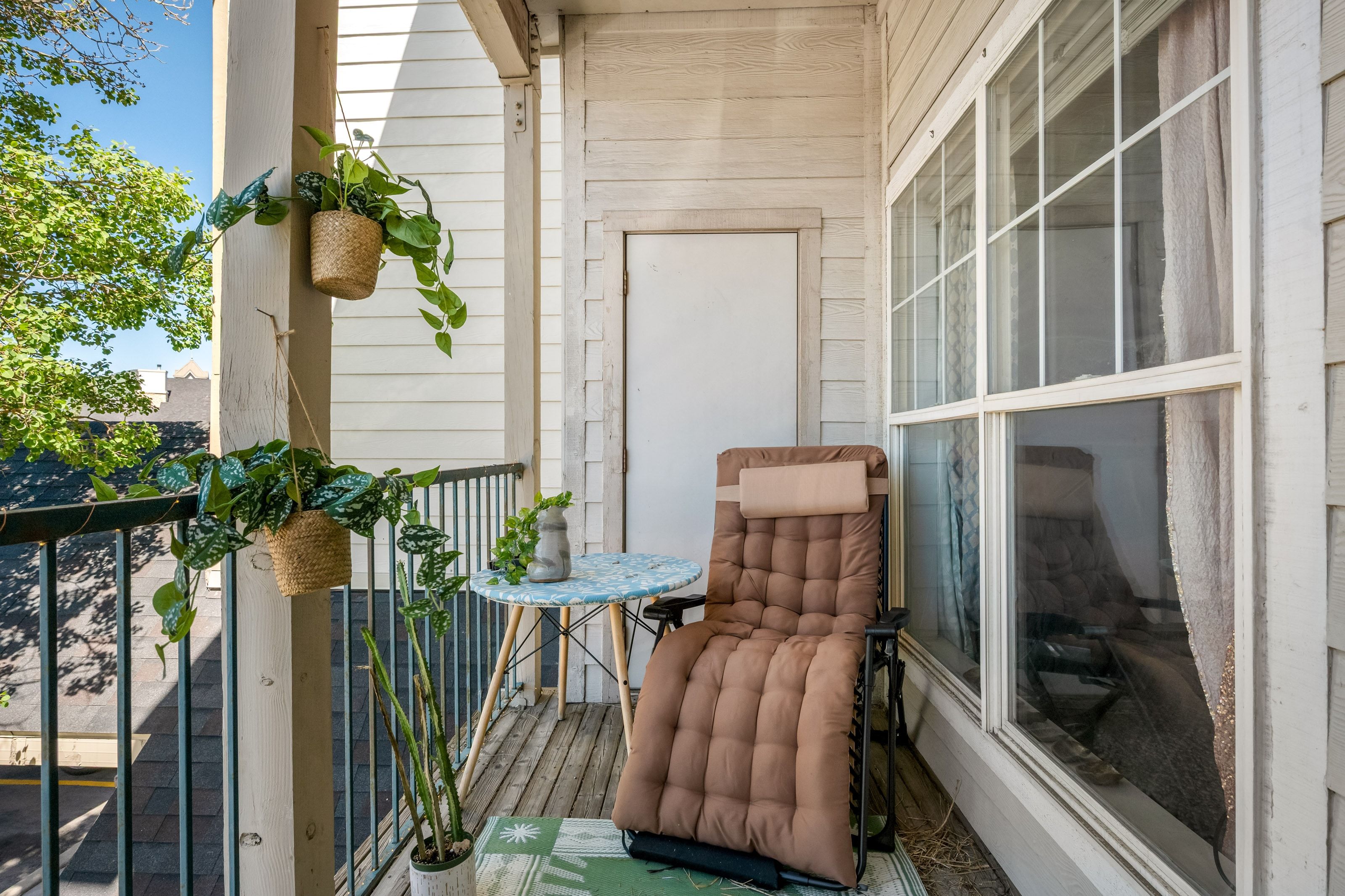 Private balcony with painted wood-finish flooring and black metal railings
