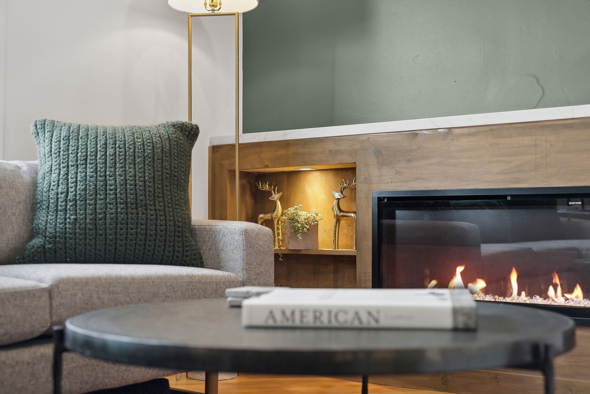 Built-in fireplace featuring a contemporary glass front, a wood-finish mantel, and an integrated illuminated niche