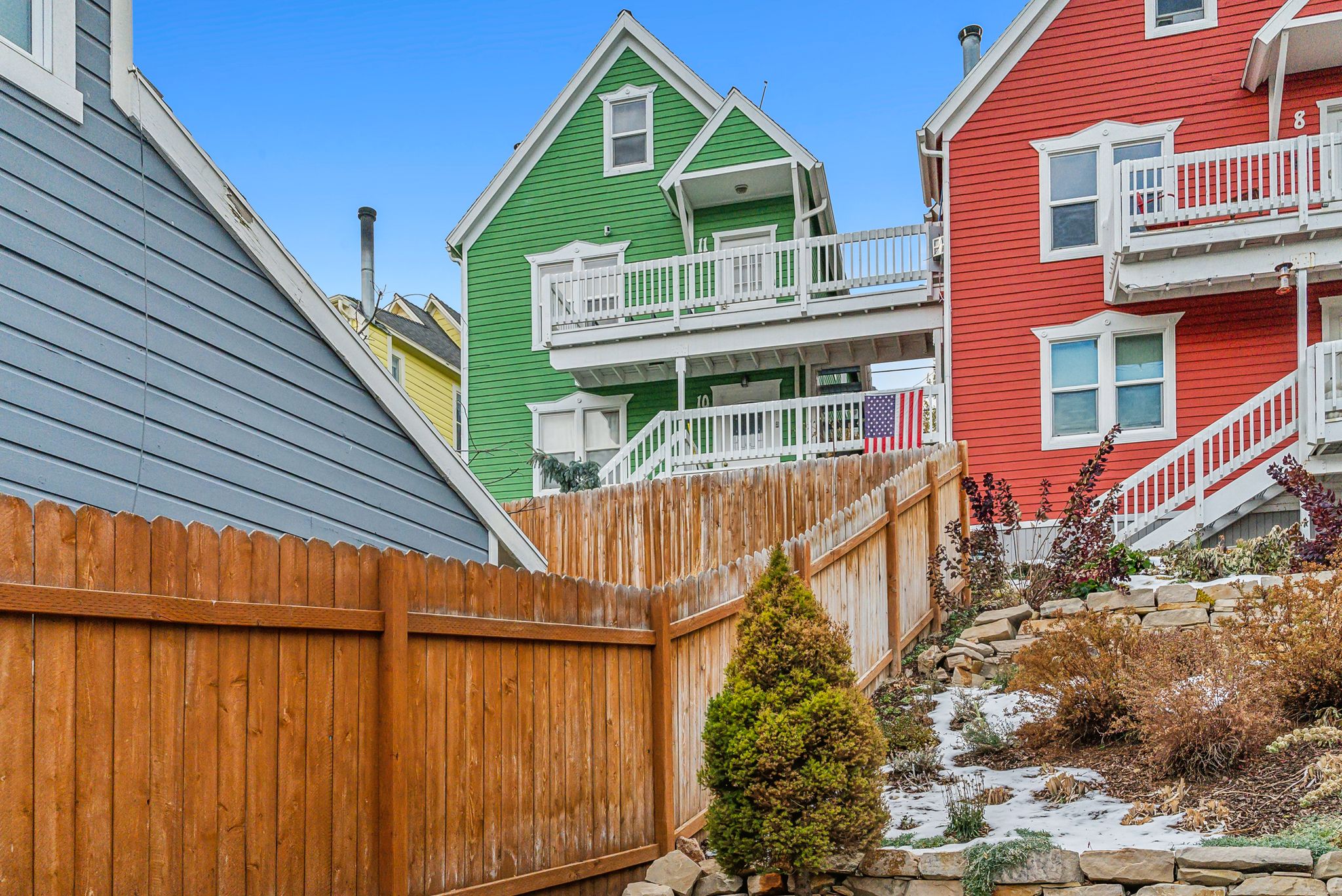 Wood picket fence bordering a terraced landscape with stone retaining walls