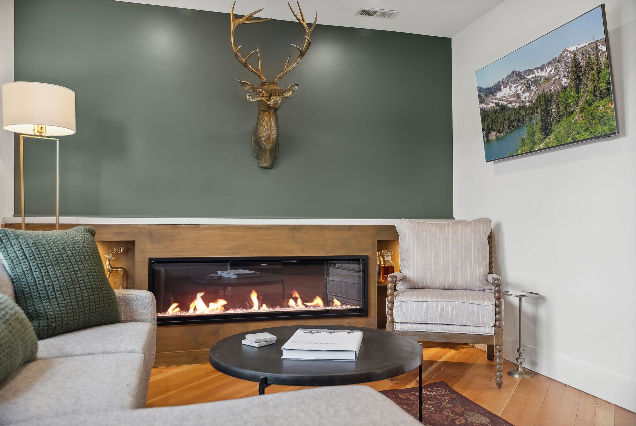 Modern linear fireplace with a light wood surround, integrated storage niche, and a contrasting accent wall