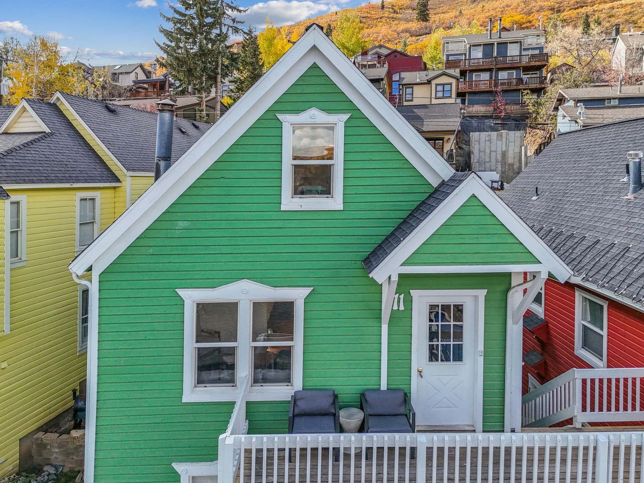 Green clapboard exterior featuring white trim and a gabled roofline