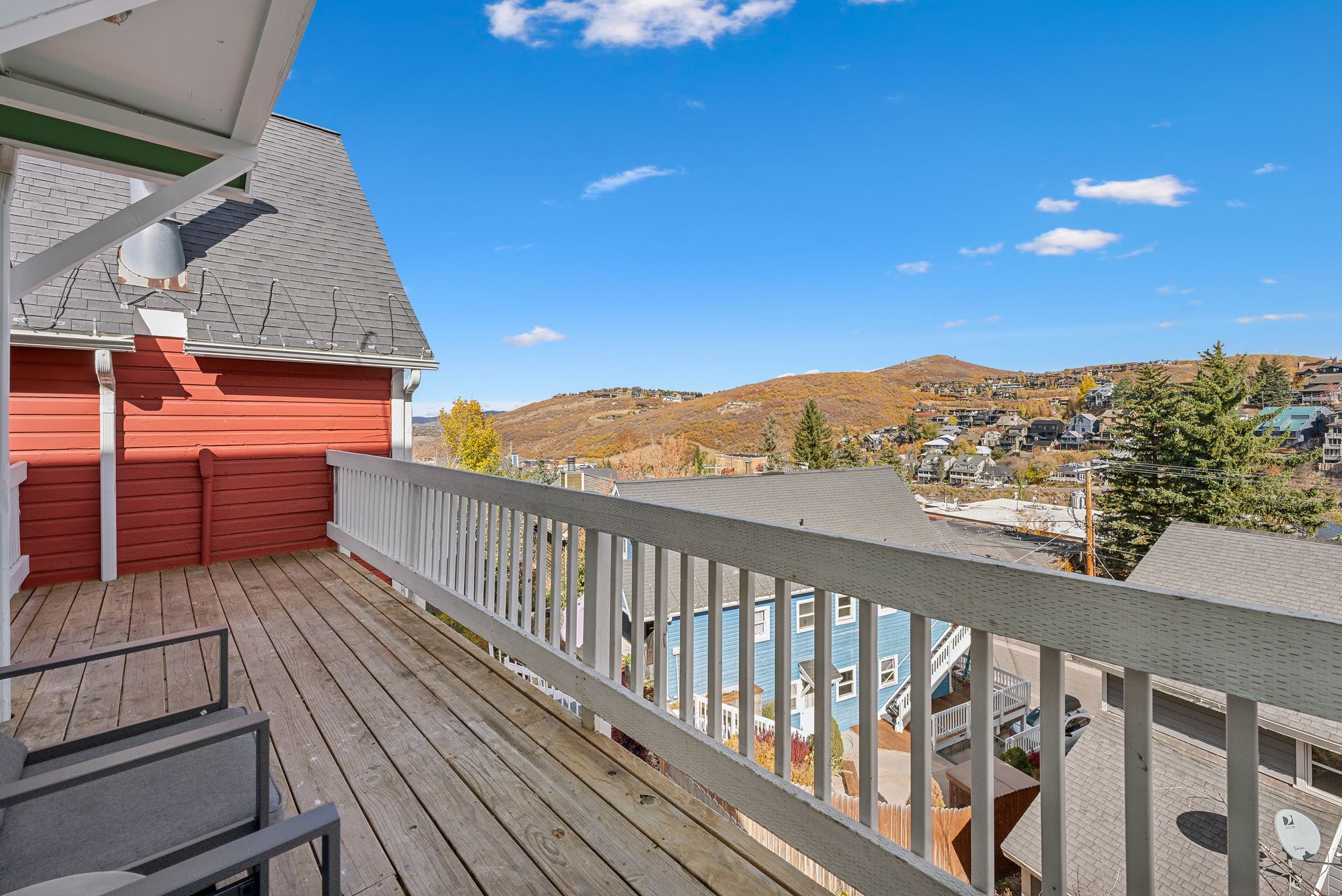 Expansive outdoor deck with natural wood flooring and white railing