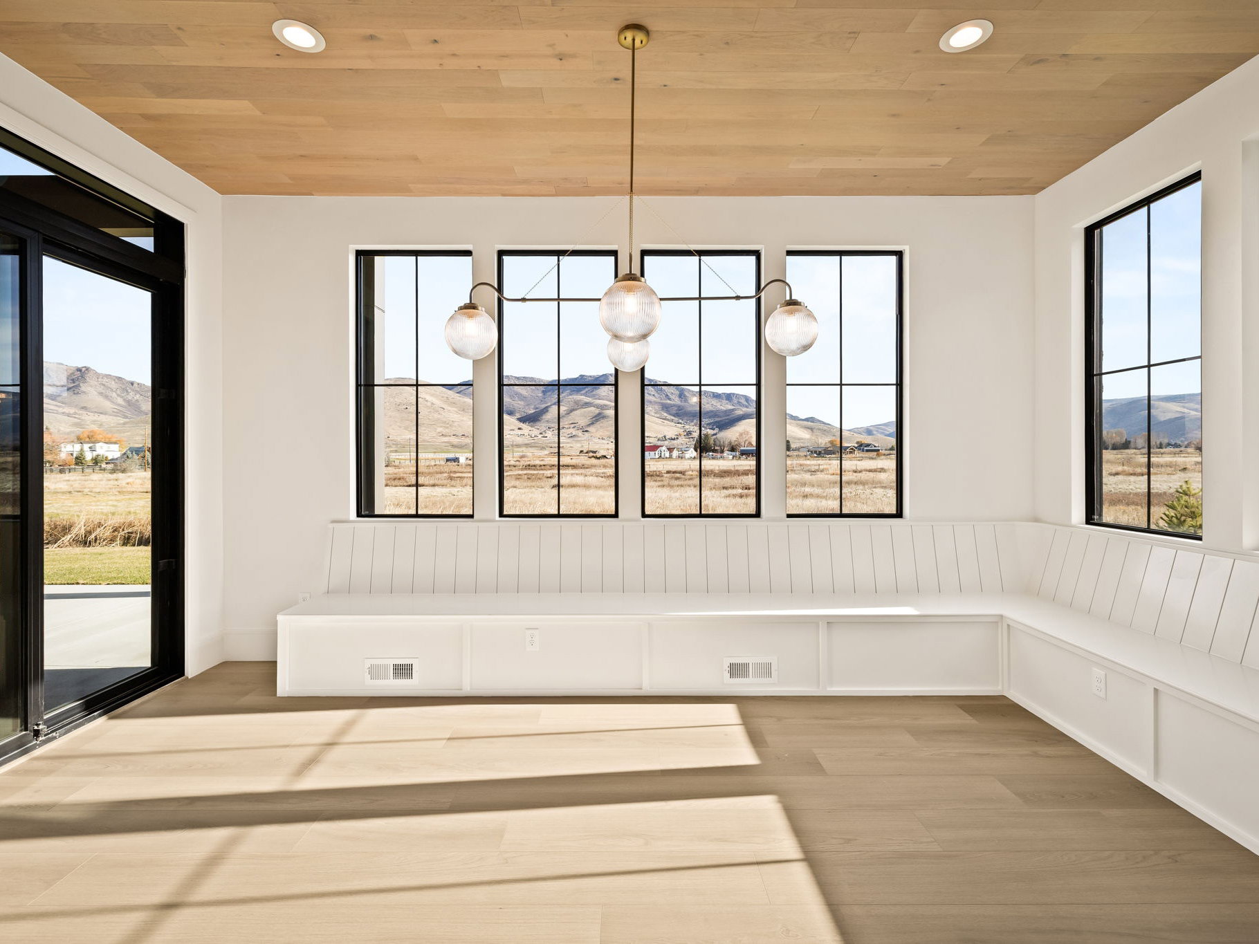 Bright room featuring panoramic windows, built-in bench seating, wood-finish flooring, a wood-paneled ceiling, and recessed lighting