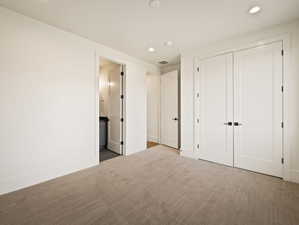 Neutral tone carpeted flooring with white baseboards