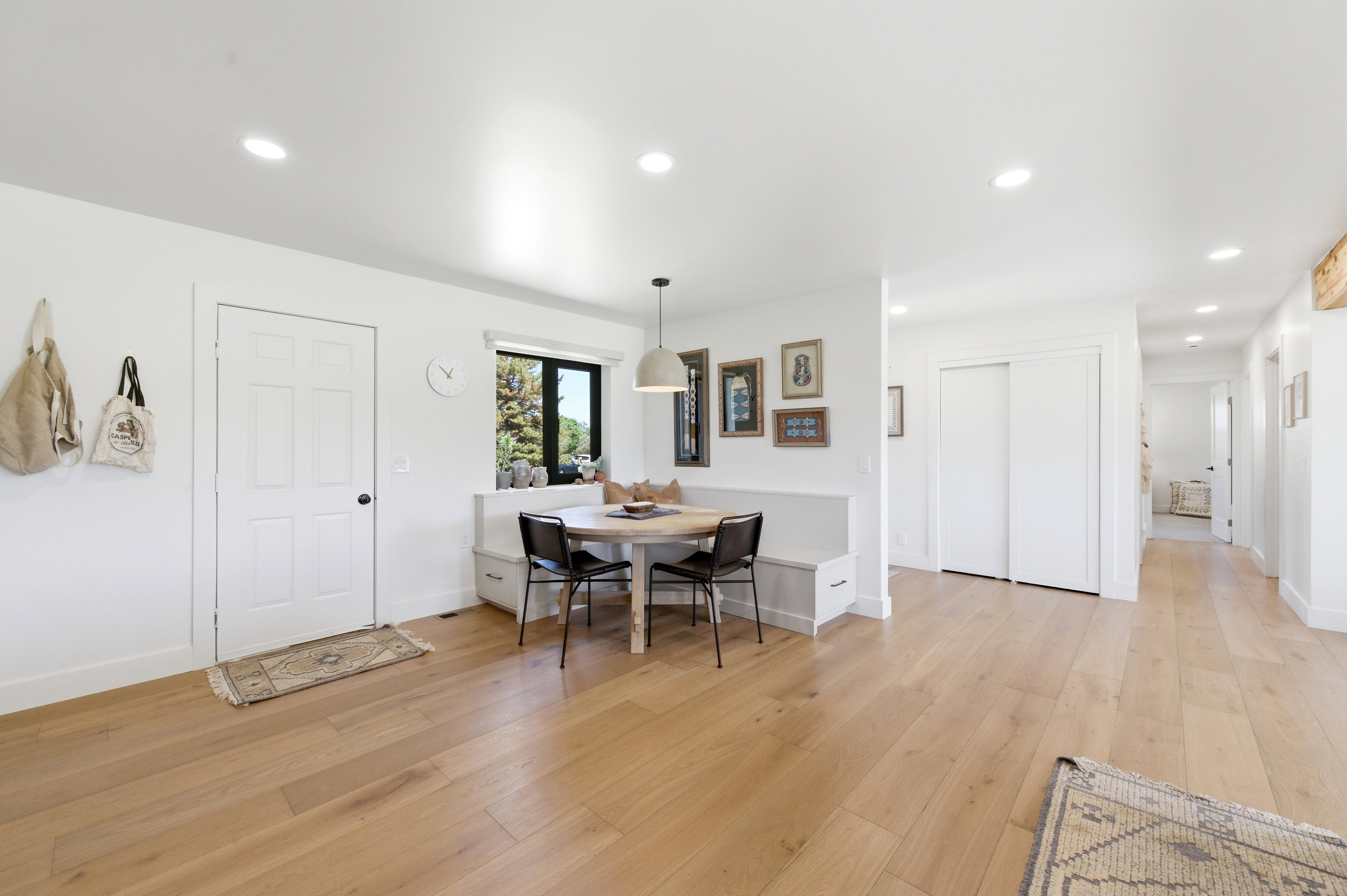 Light wood-finish flooring extending through an open-concept interior featuring recessed lighting