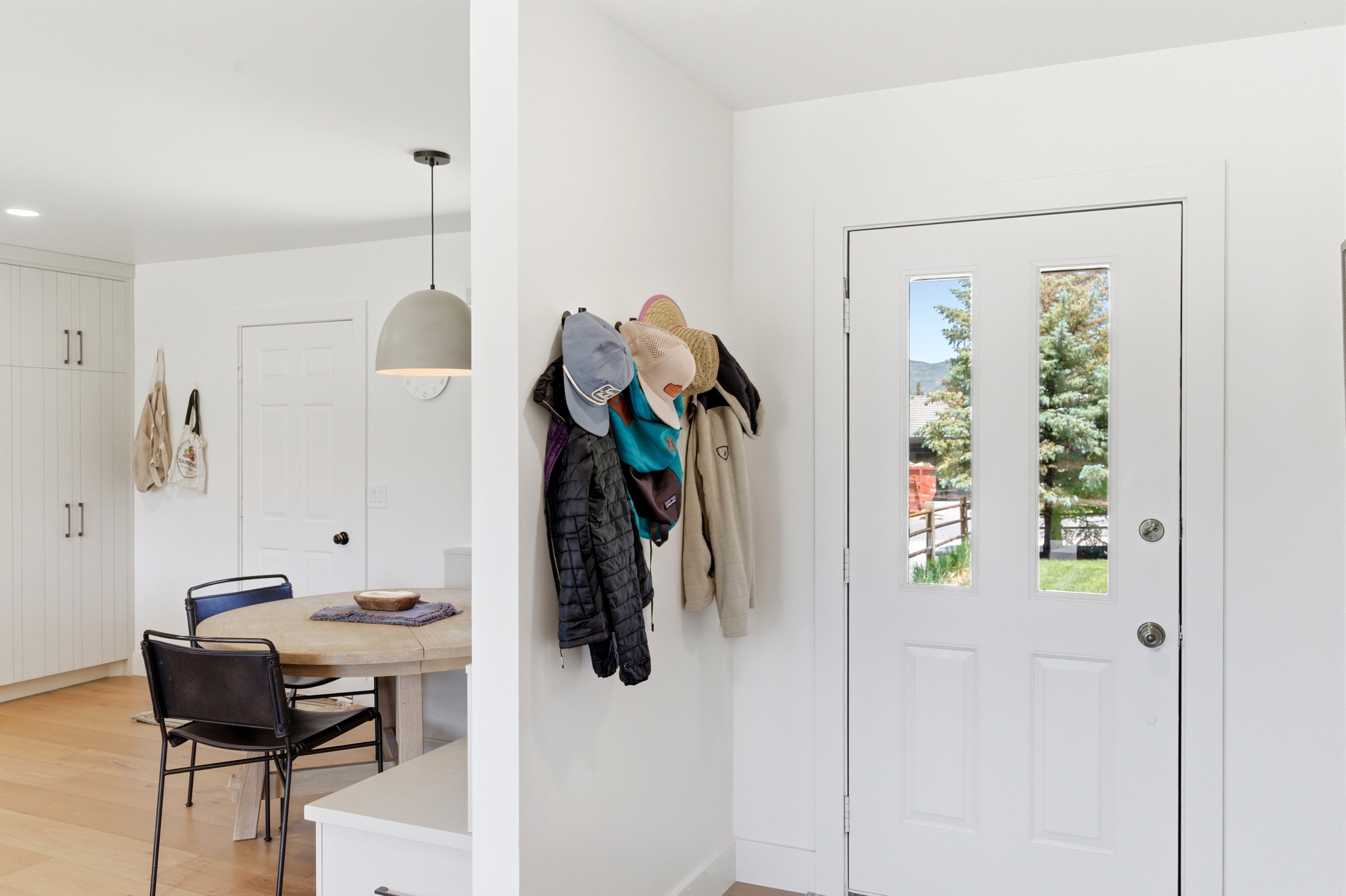 Entry door featuring two vertical glass inserts, white trim, and a brushed nickel door handle