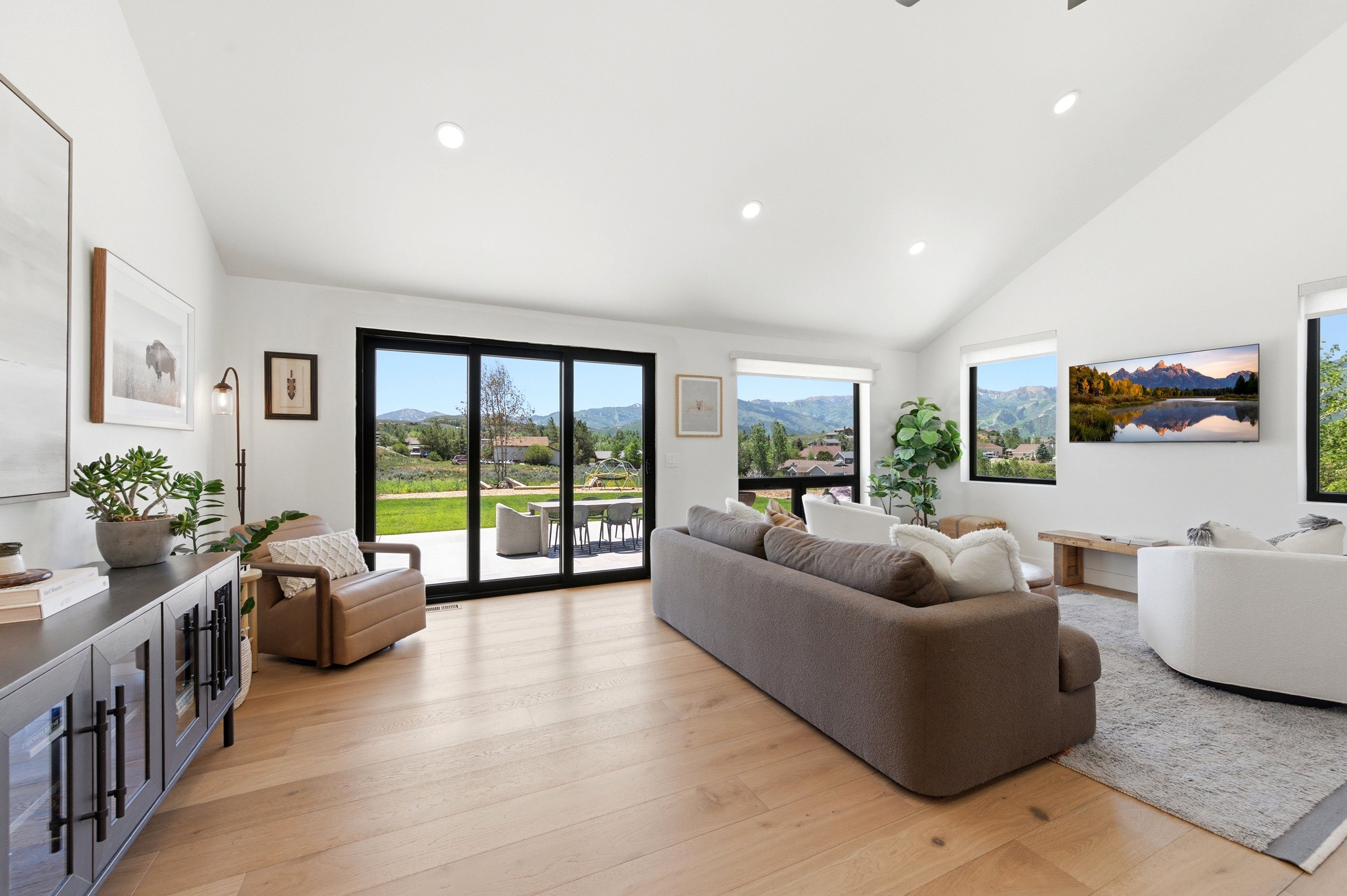 Bright living space featuring a vaulted ceiling and light wood-finish flooring