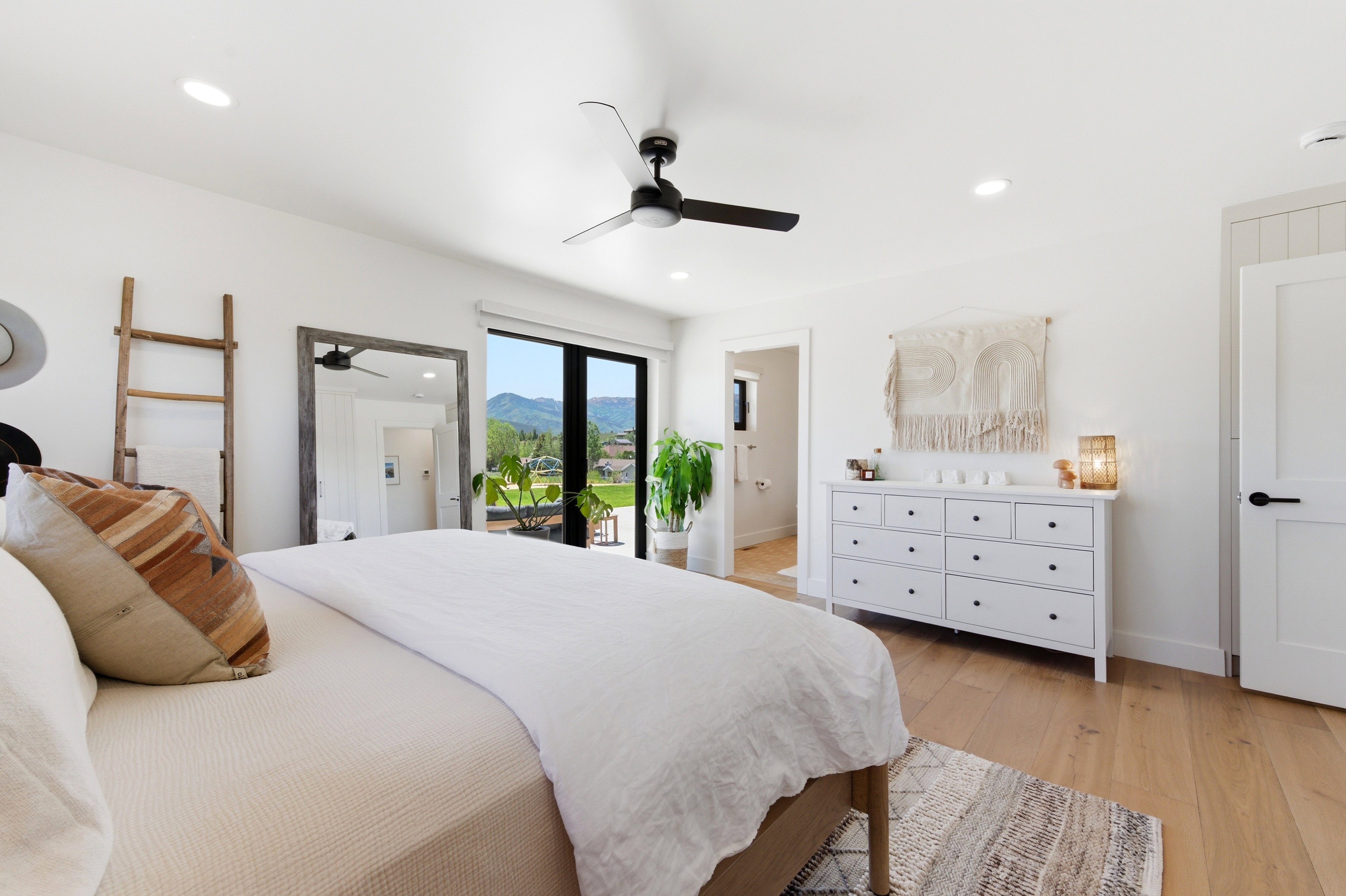 Spacious room featuring wood-finish flooring and a contemporary black ceiling fan