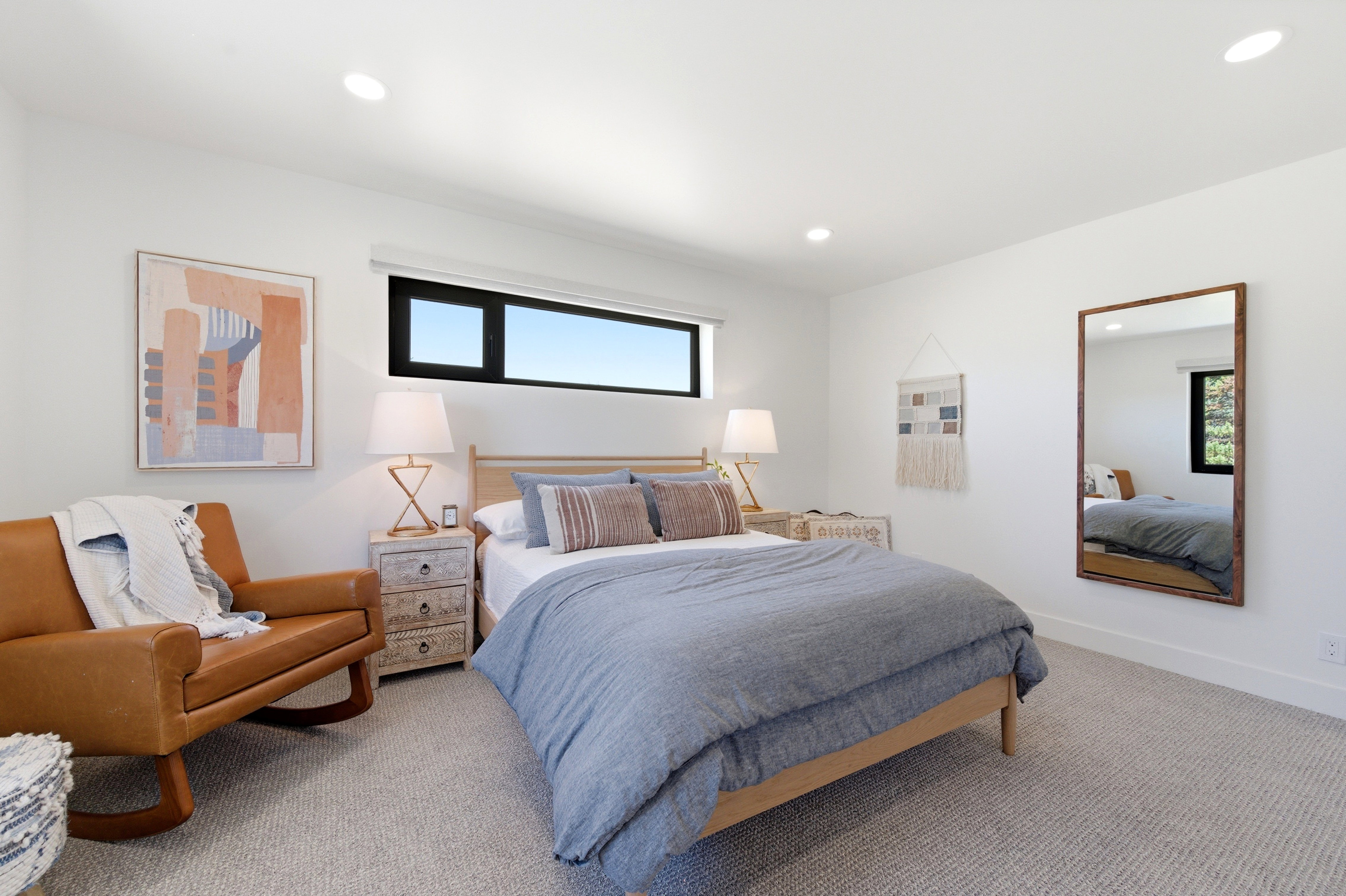 Carpeted room featuring a horizontal window with black framing, recessed lighting, and white walls
