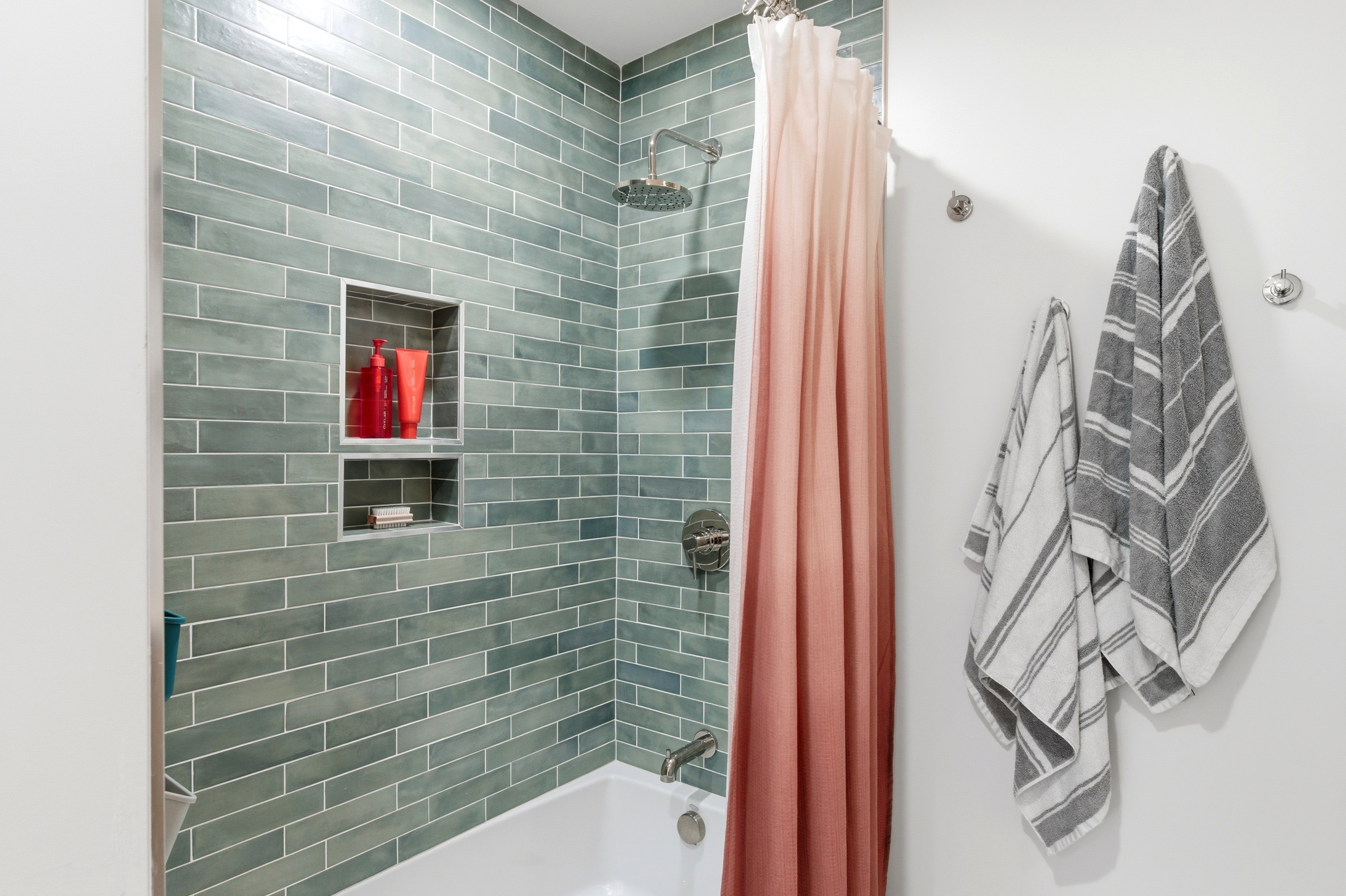 Bathroom featuring subway tile shower surround in a subtle green hue