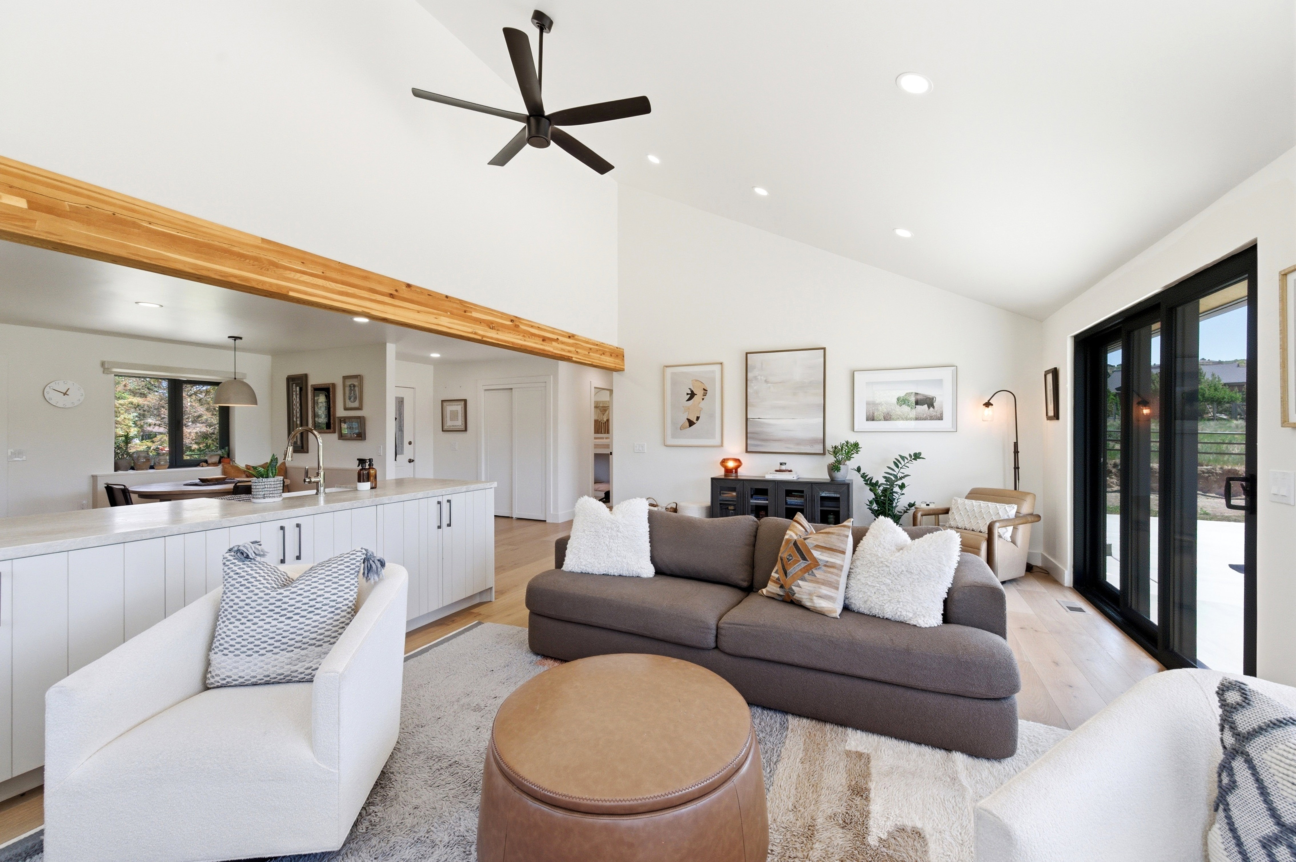 Vaulted ceilings and recessed lighting illuminate an open-concept living area with light wood-finish flooring
