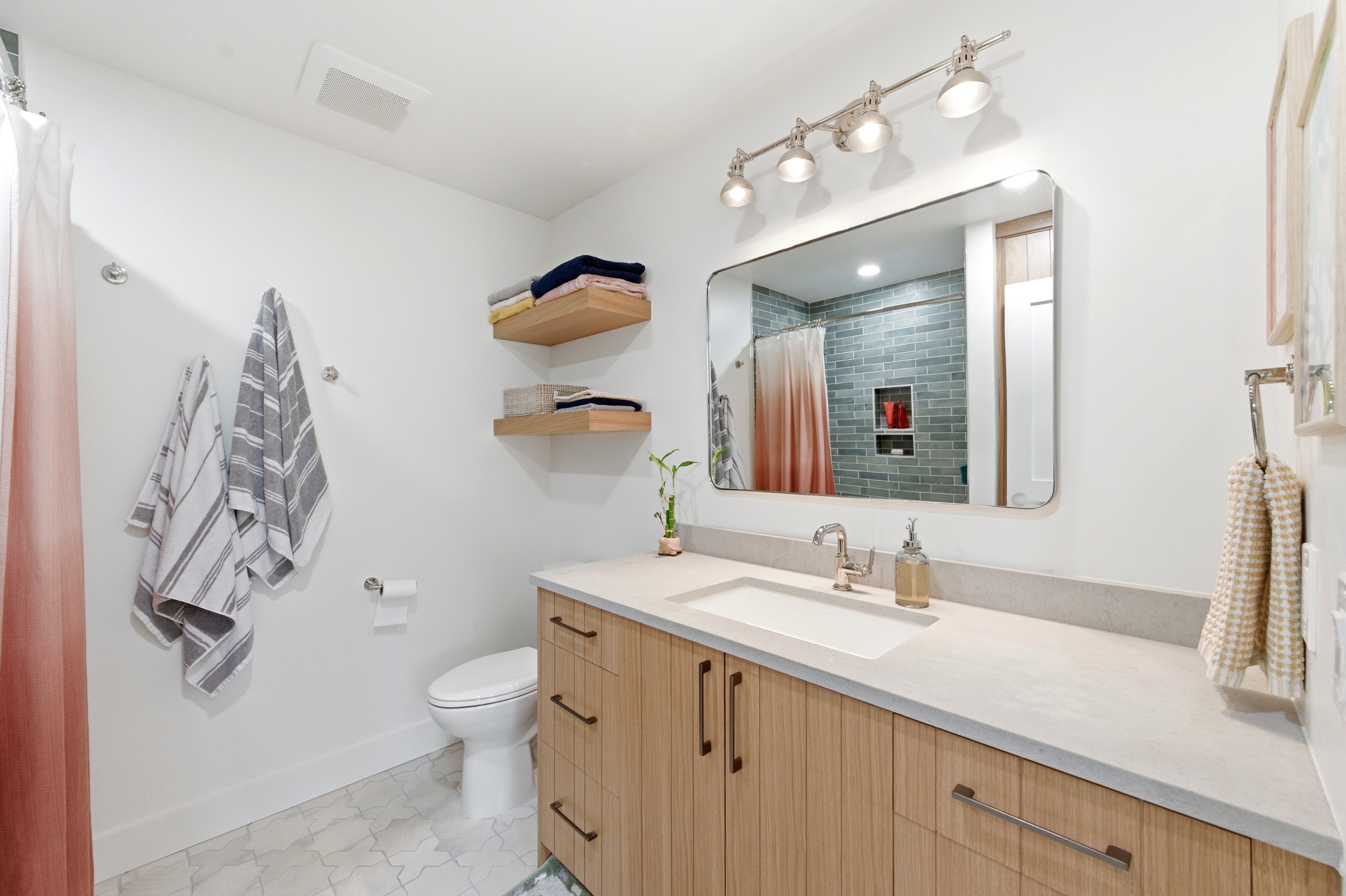 Bathroom vanity with a light wood-finish cabinet, integrated sink, and light-toned countertop