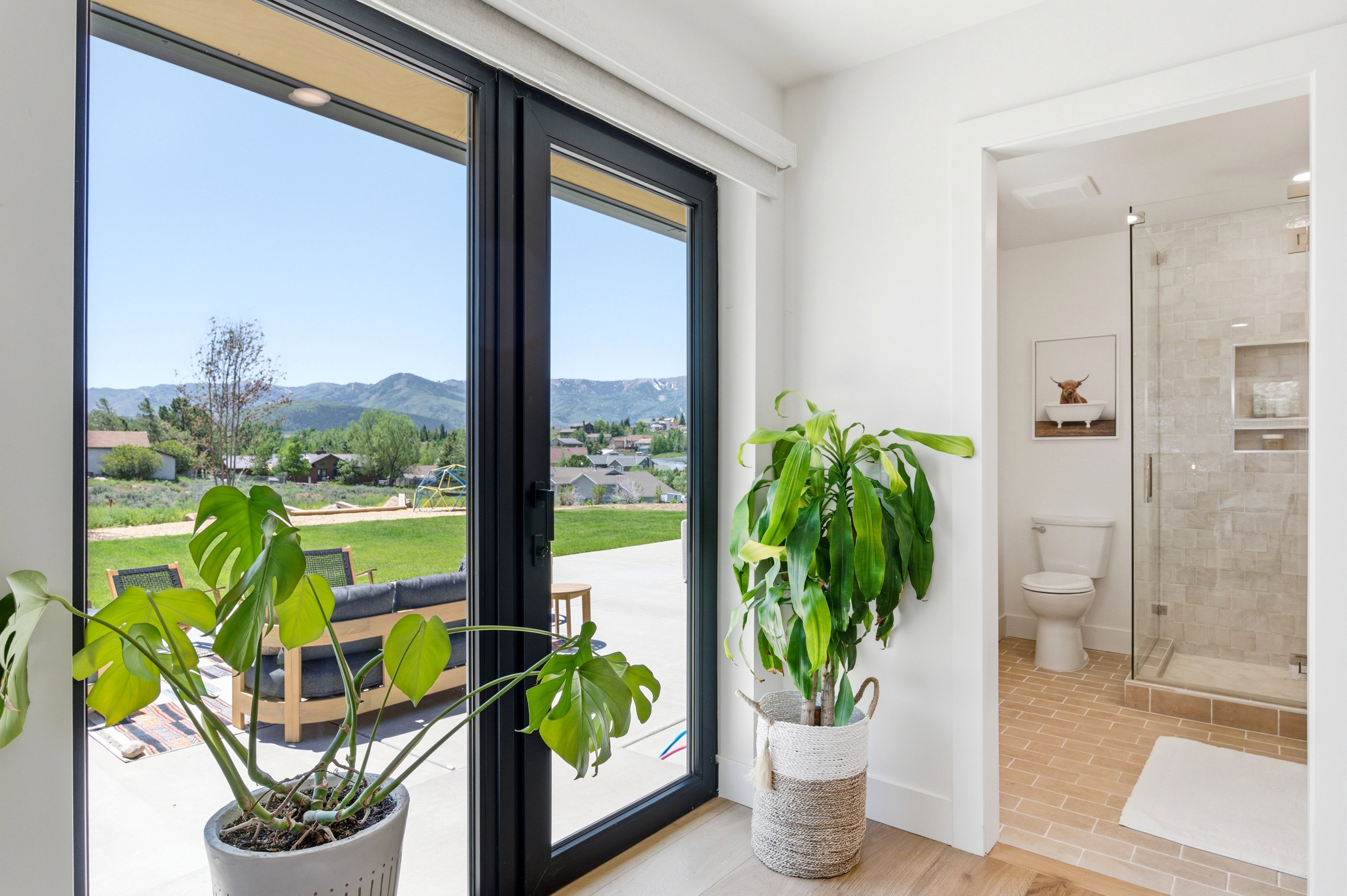 Sliding glass doors opening to an outdoor patio with mountain scenery