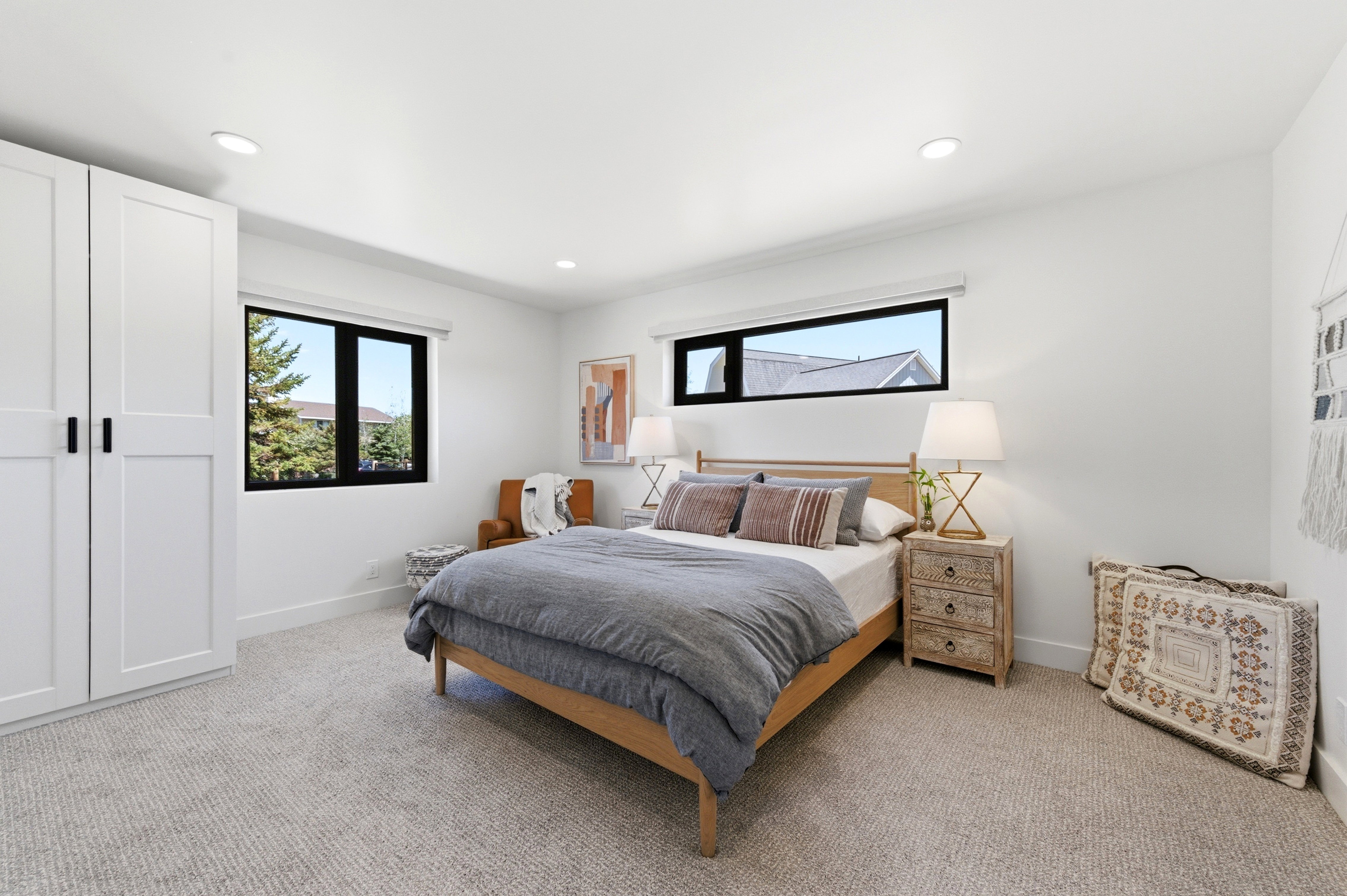Spacious bedroom featuring light-toned carpeting and recessed lighting